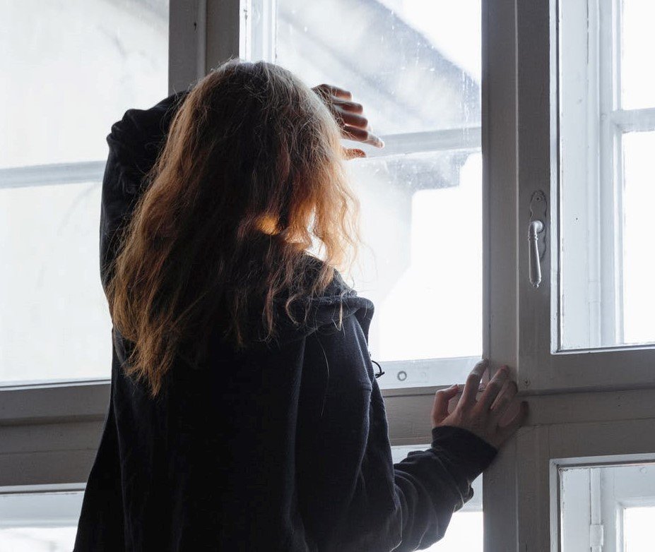 With her face pressed against the dusty glass of the old lady's home and her attention held down by the objects, June got carried away | Source: Pexels