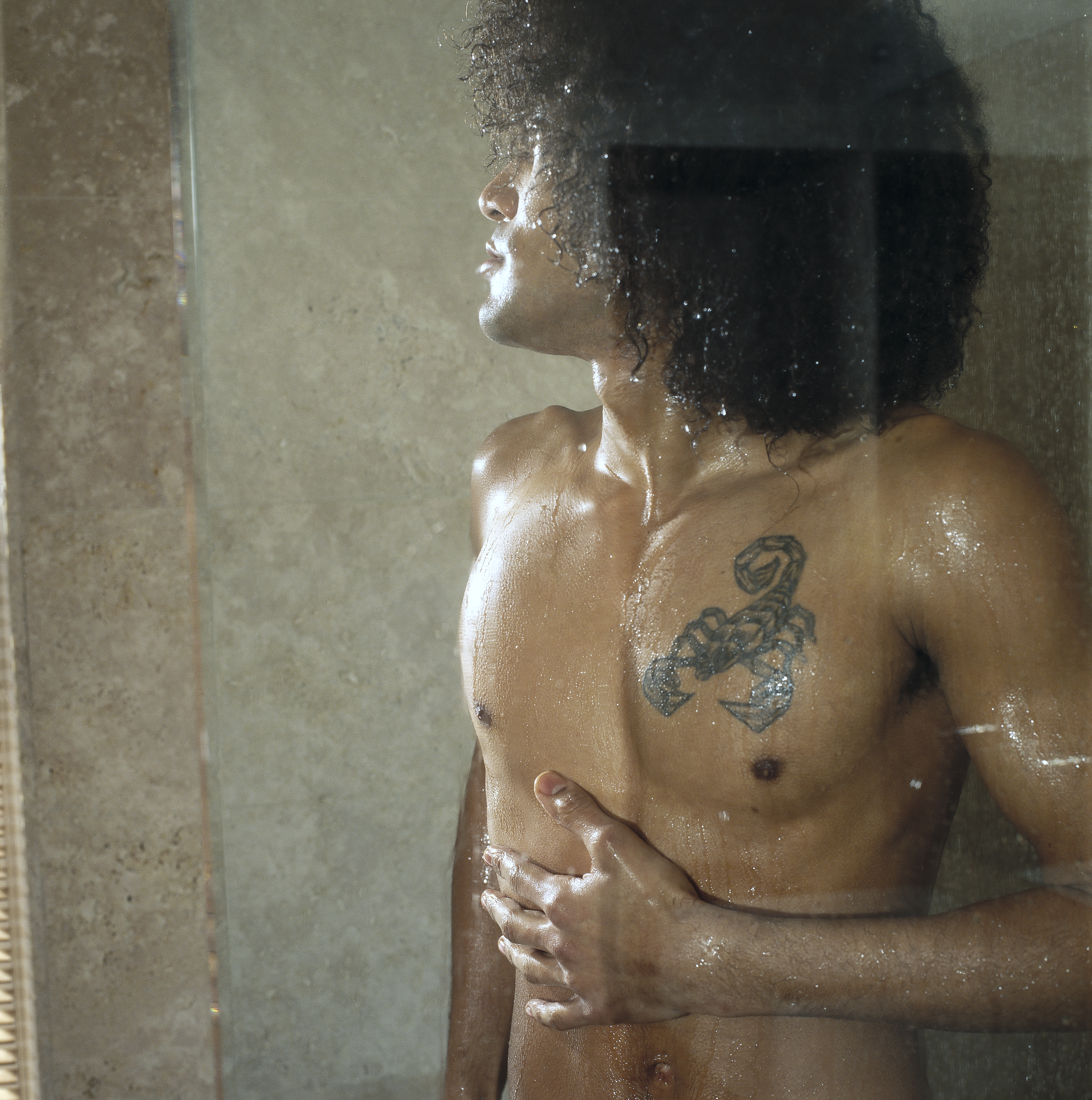 Bare chested man showering | Source: Getty Images