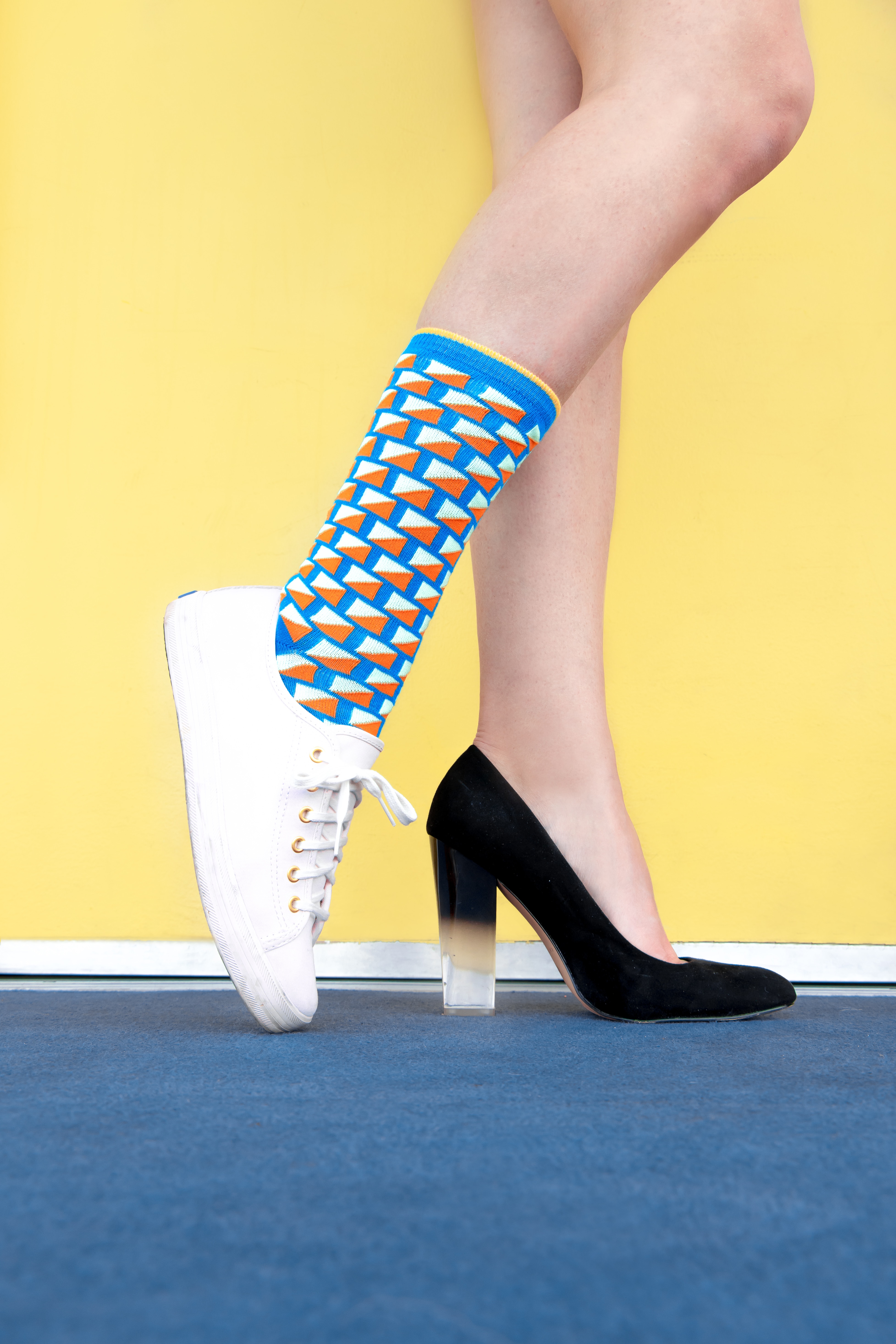 An individual wearing two different shoes with a colorful sock. | Source: Unsplash