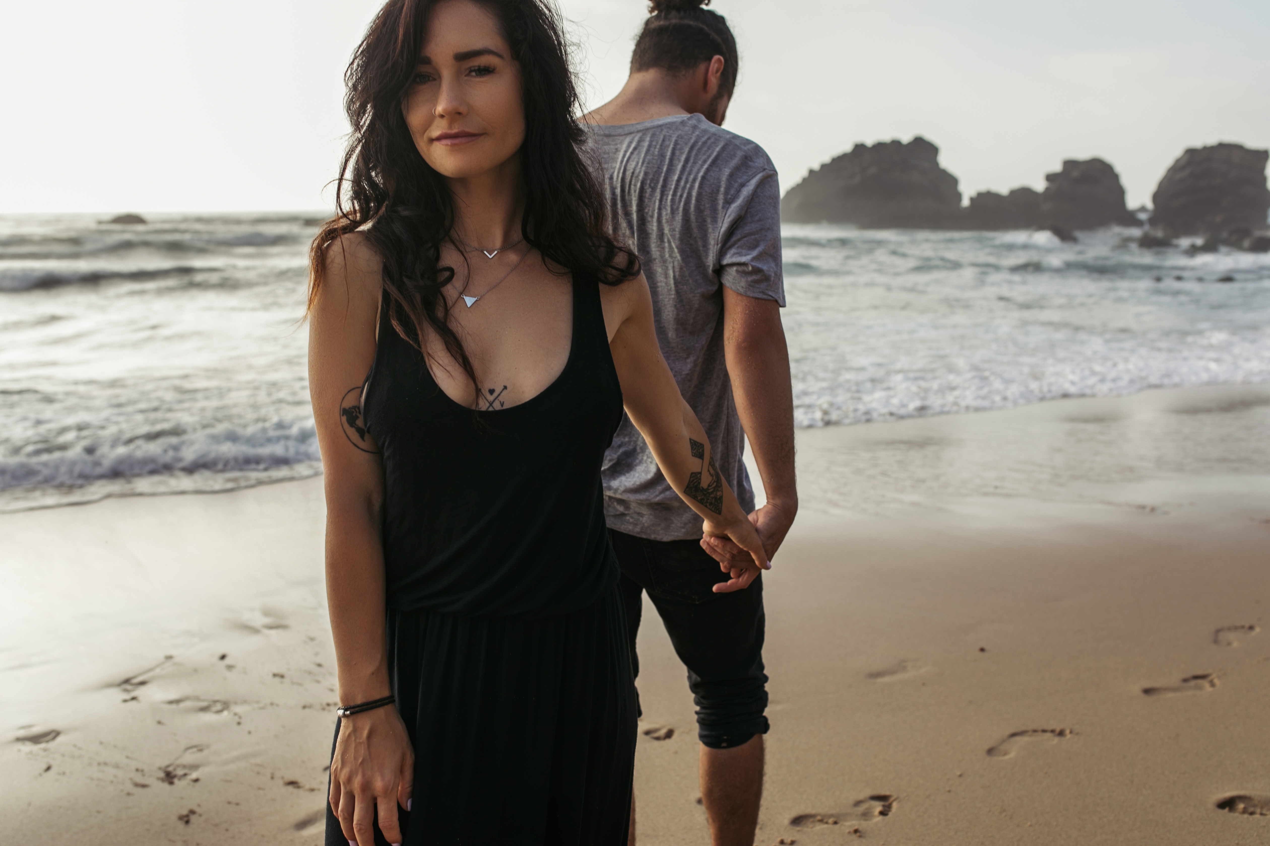 A man and a woman holding hands at the beach | Source: Getty Images