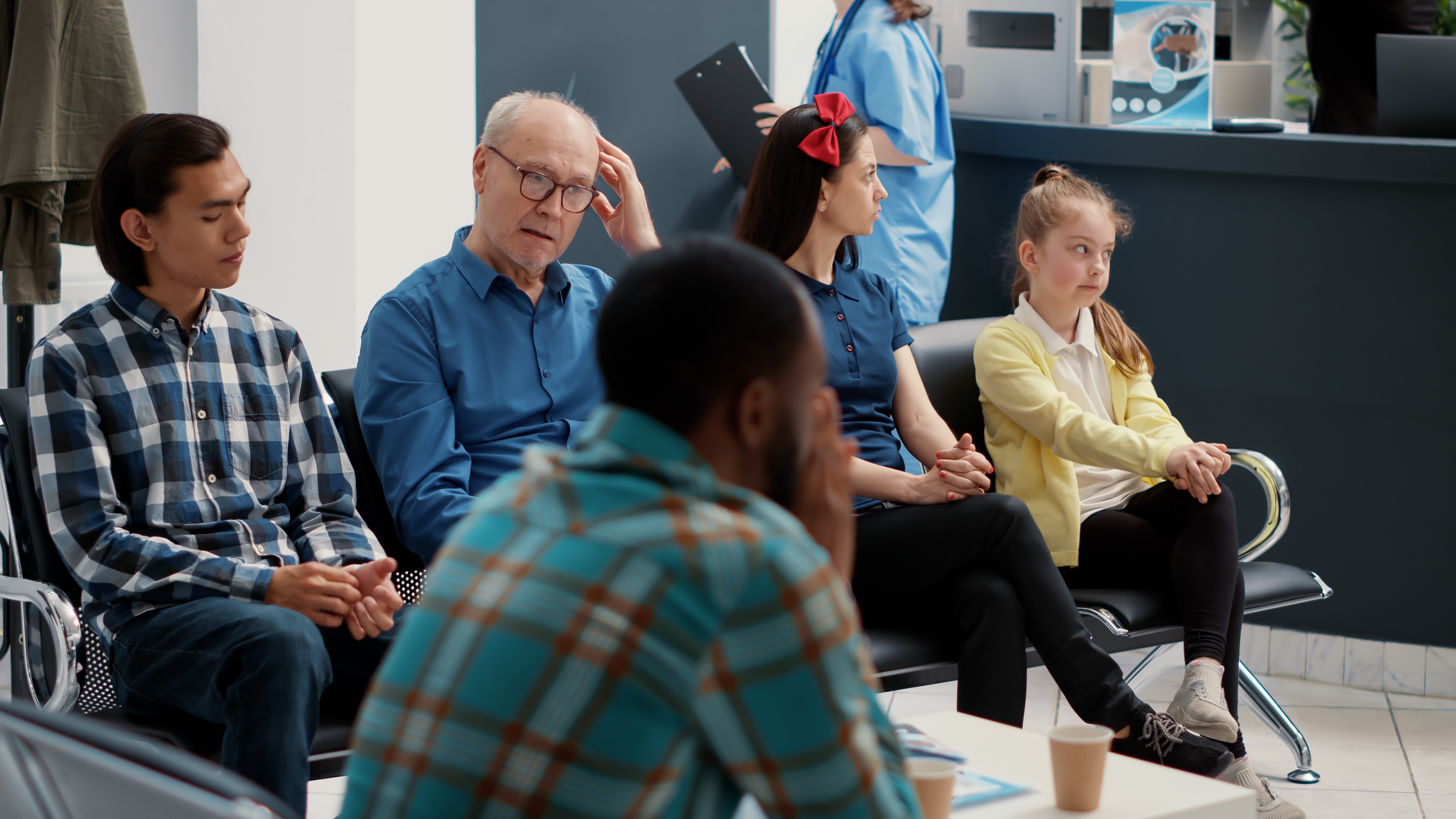 Diferentes personas esperando en fila en un hospital | Fuente: Shutterstock