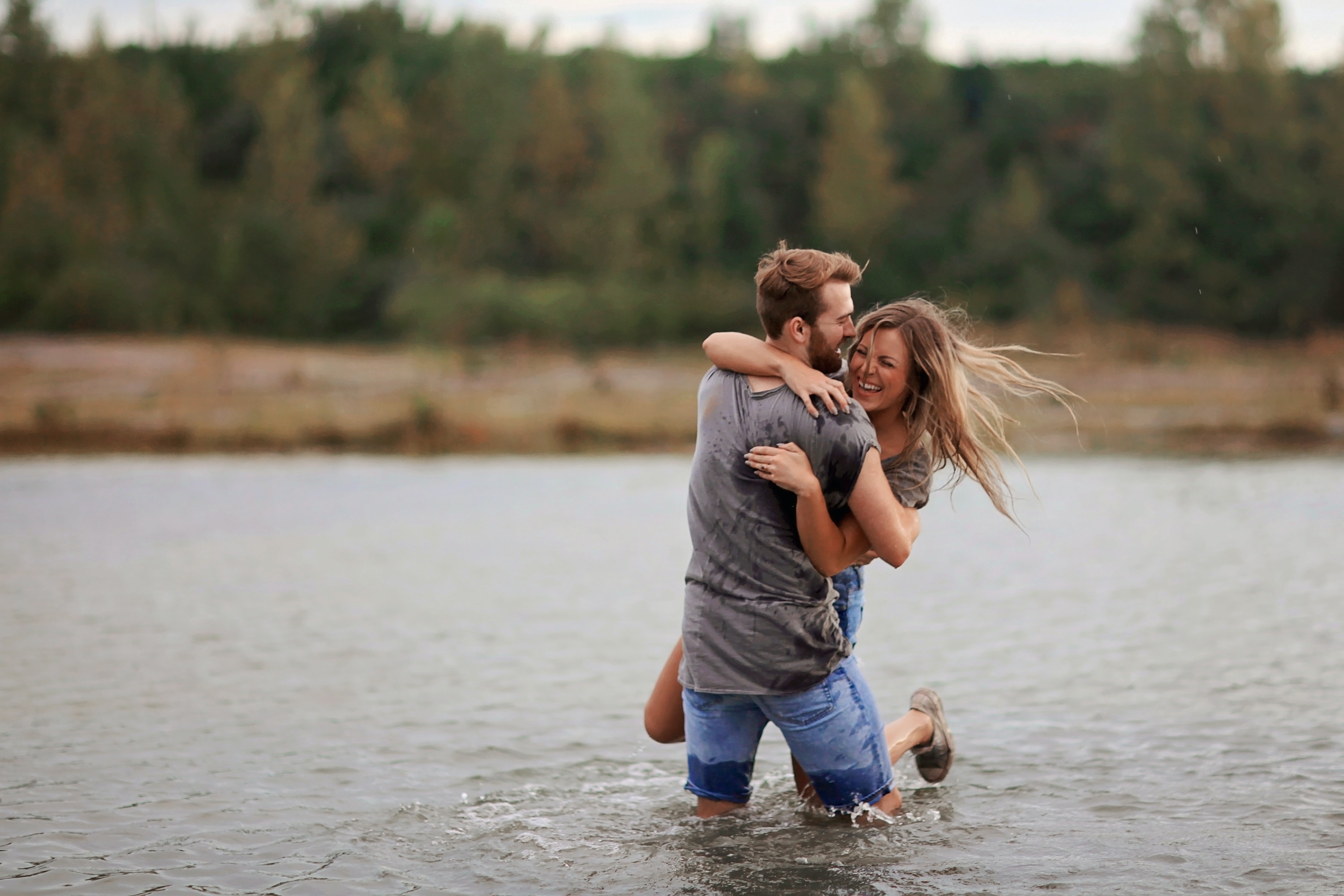 Couple playing in the water. | Source: Pexels