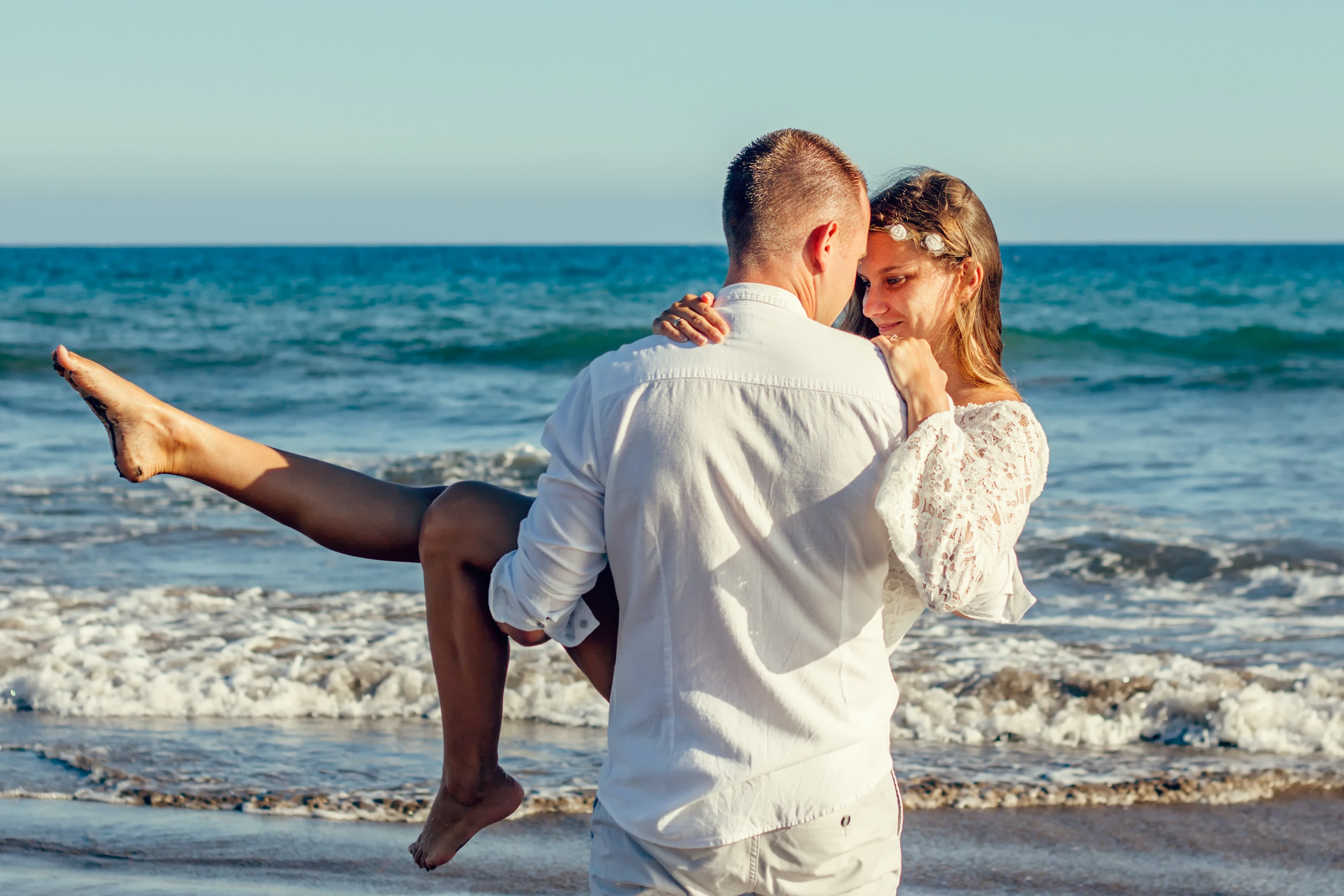 Man carrying woman in front of the beach. | Source: Pexels