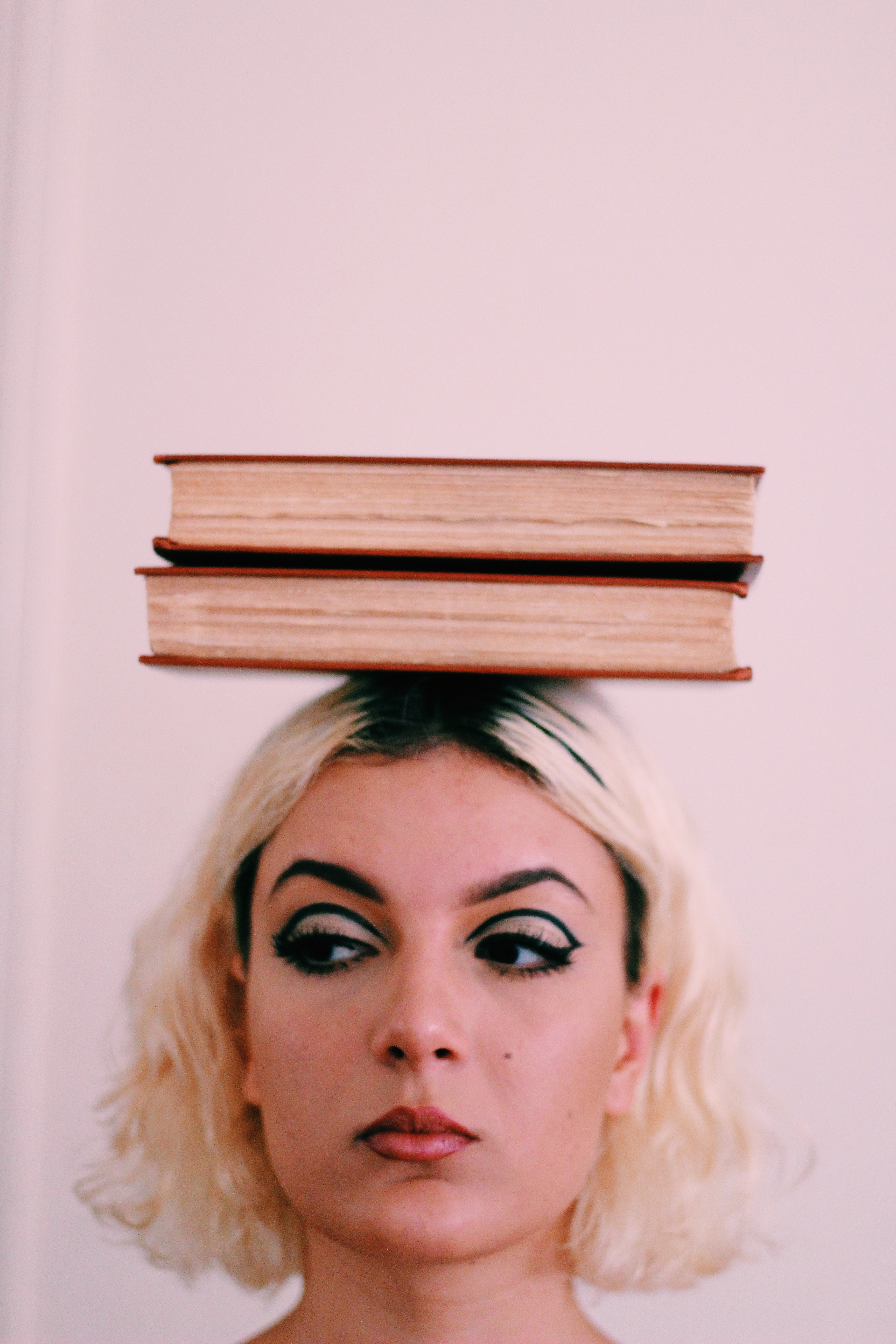 A woman balancing books on her head. | Source: Pexels