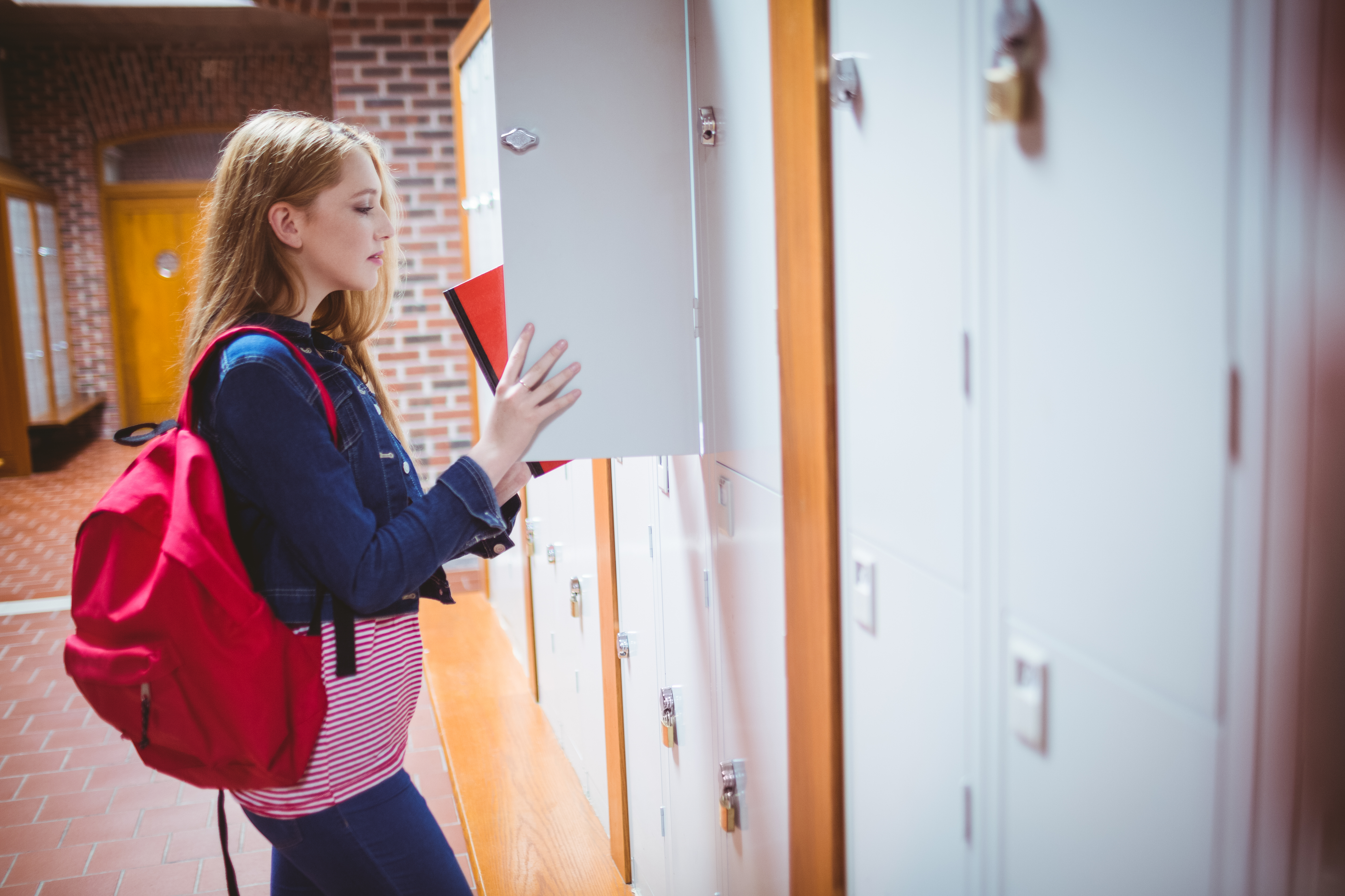A student putting books in a locker | Source: Shutterstock