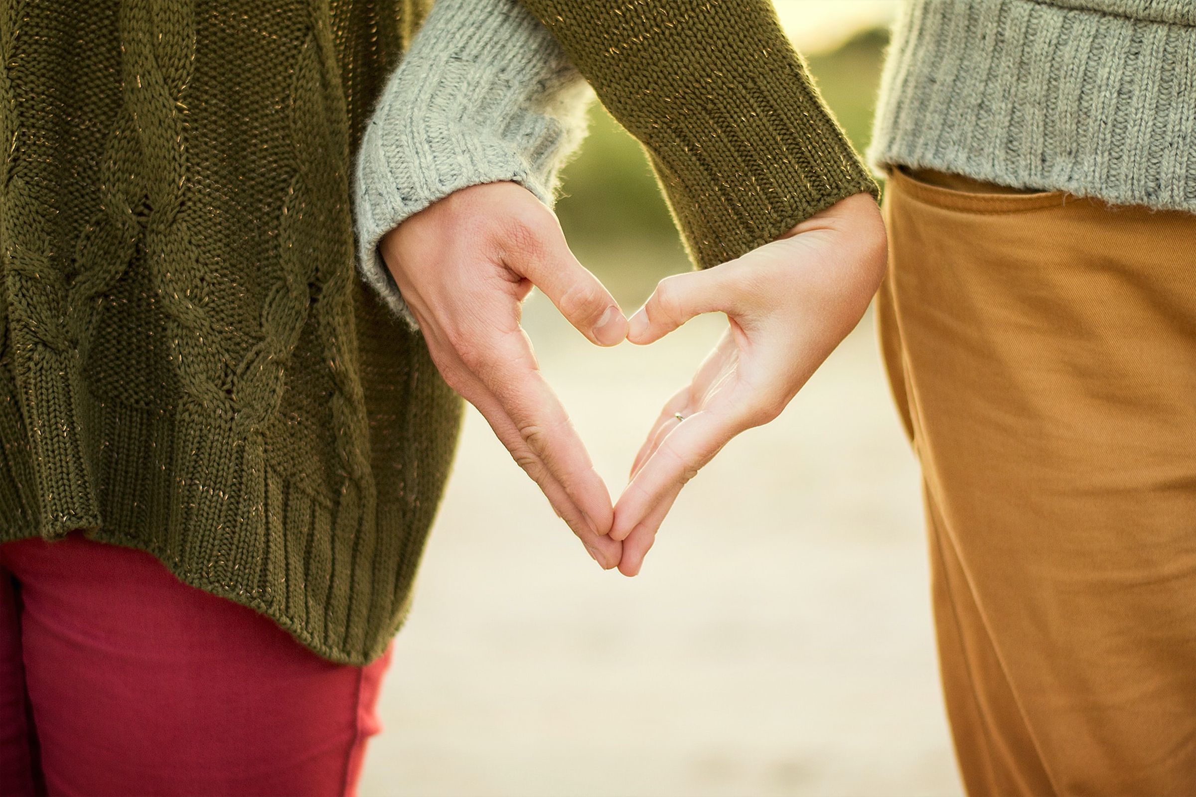 Two individuals putting their hands together to make a heart. | Source: Unsplash