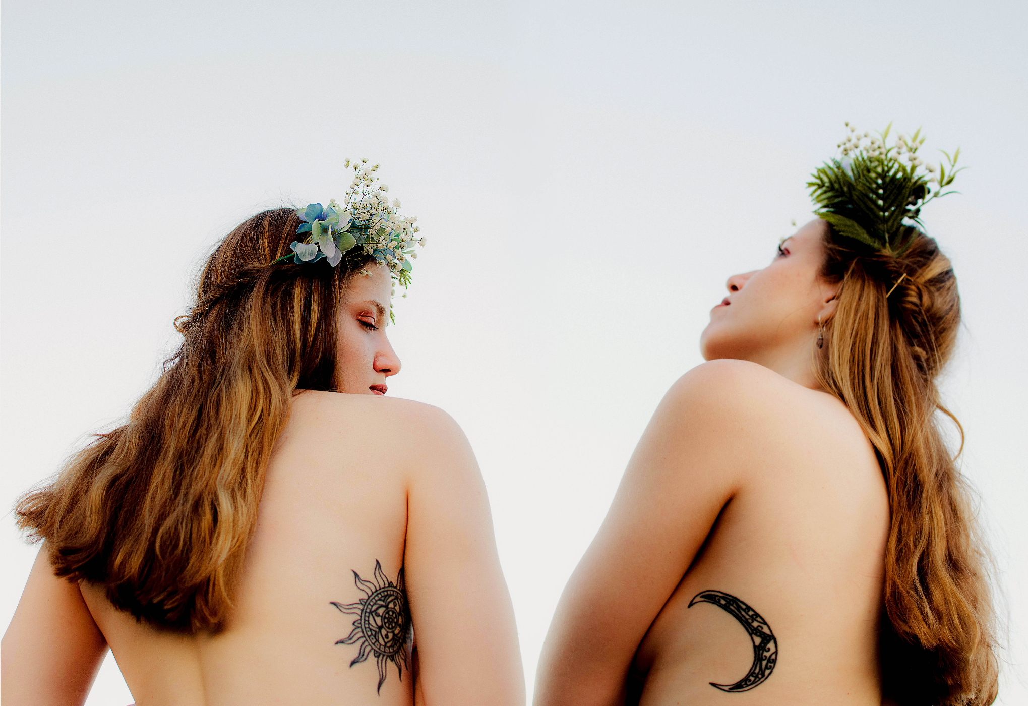 Two woman with tattoos and leaf crowns. | Source: Unsplash