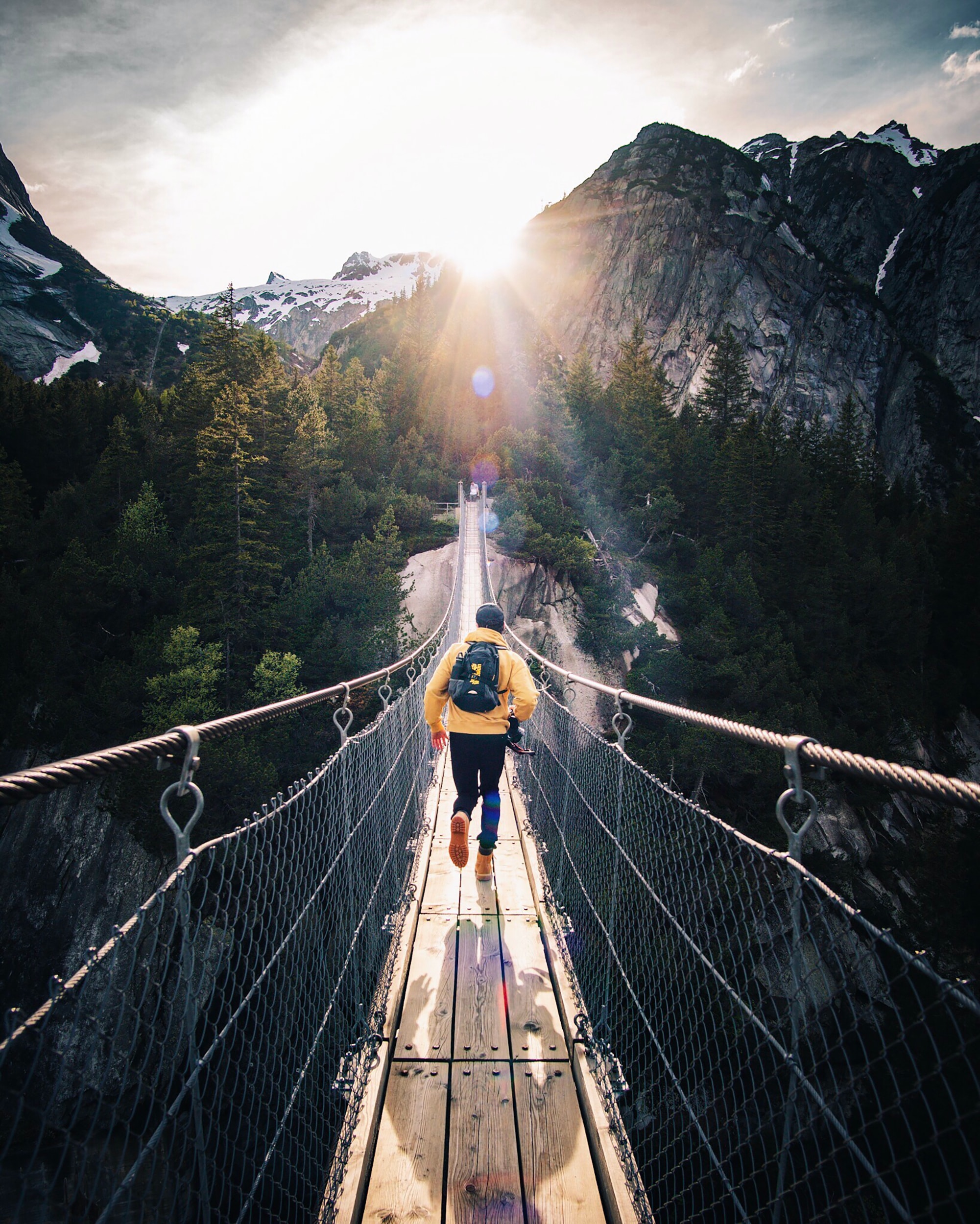 An individual running across the bridge in the mountains.│Source: Unsplash