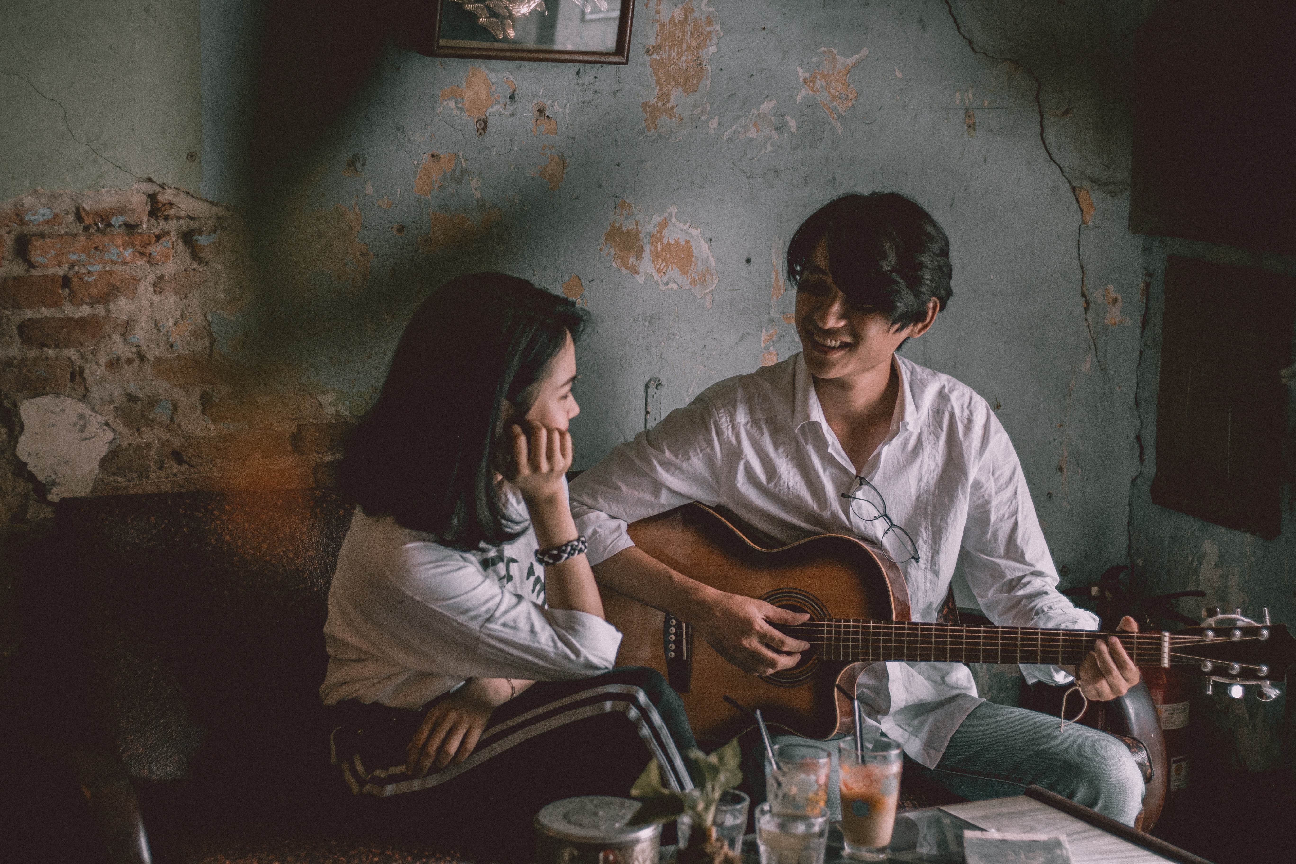 A man playing the guitar for a woman. | Source: Pexels