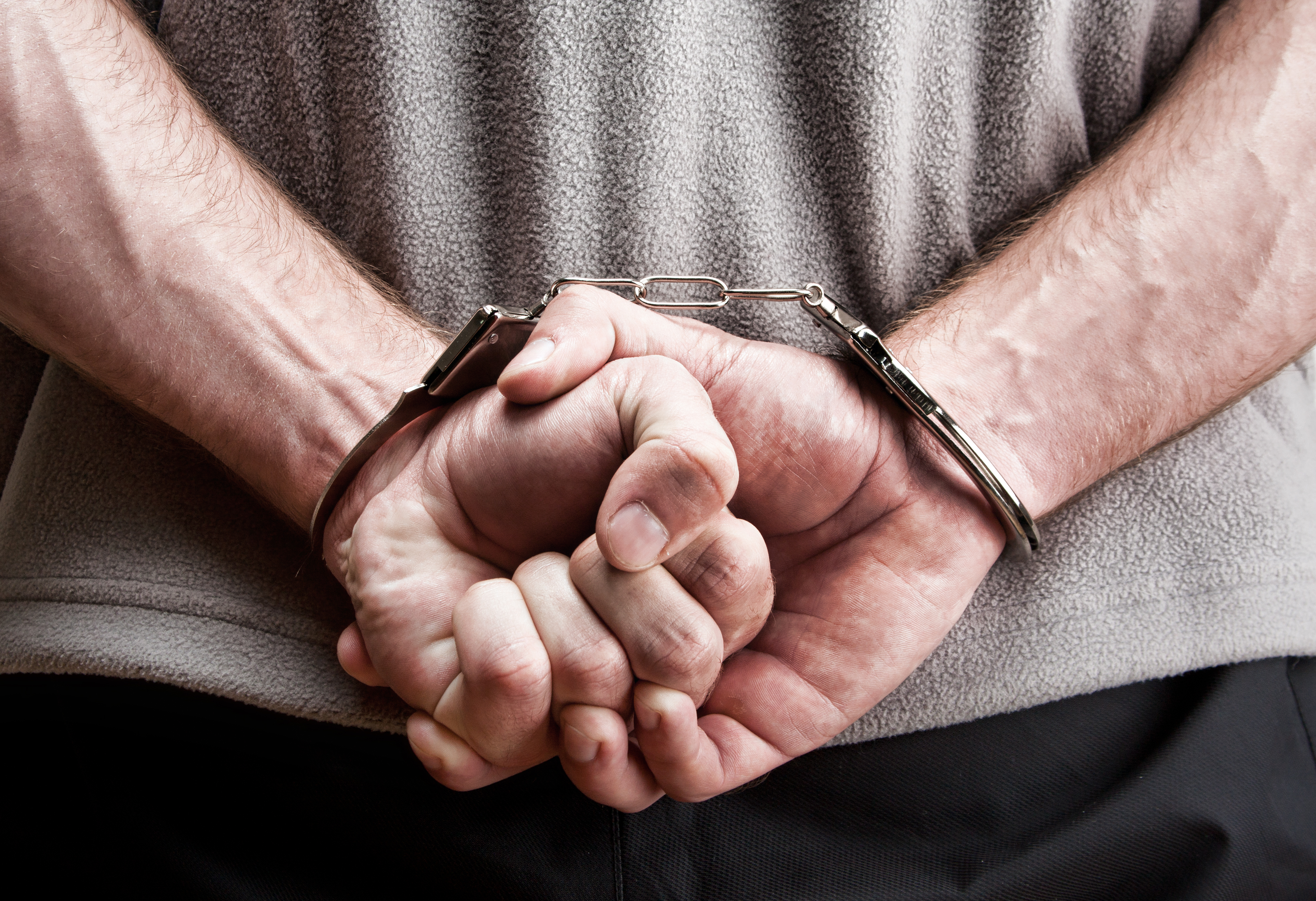 Manos criminales esposadas. | Fuente: Shutterstock