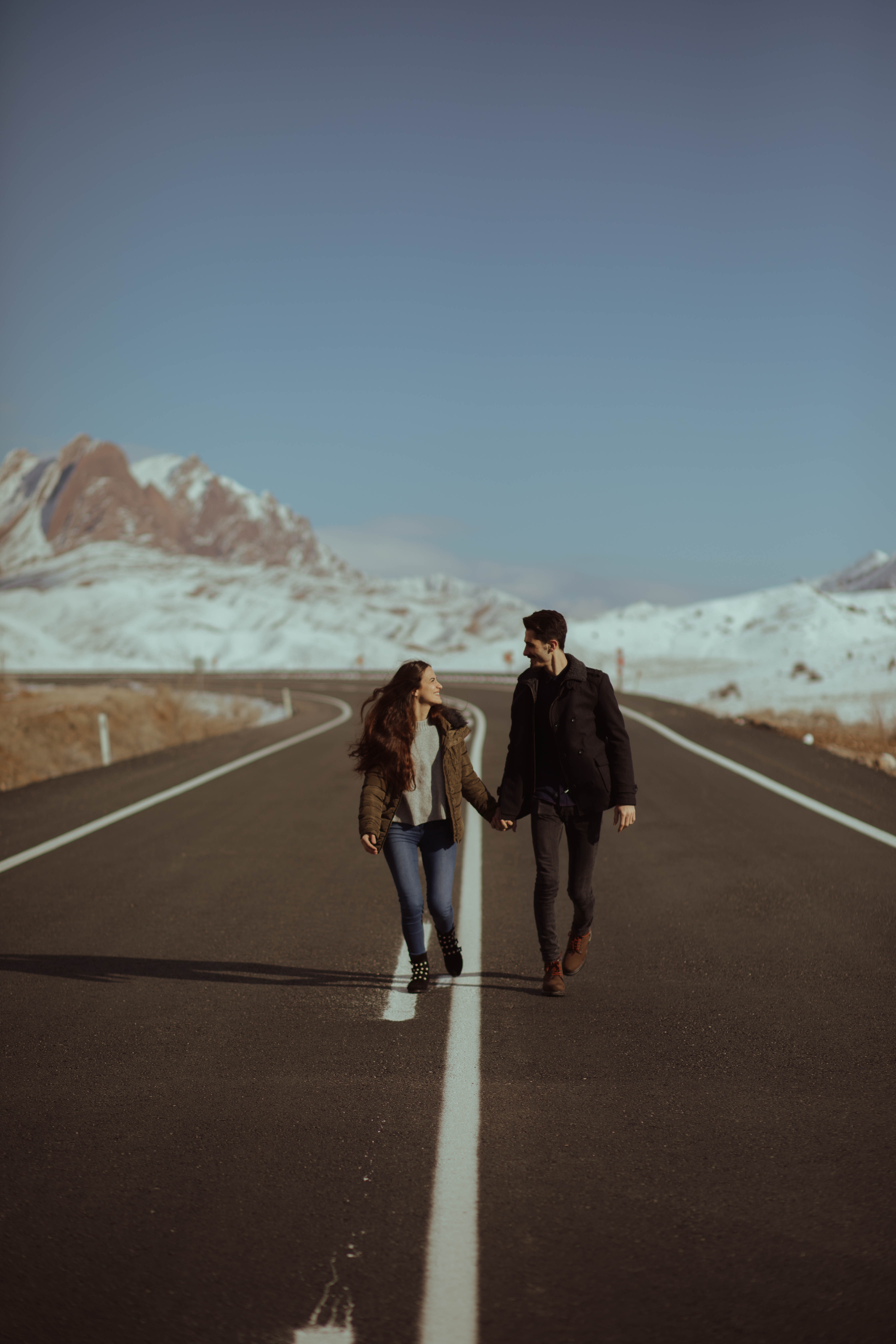 A couple walking in the middle of the road together. | Source: Pexels