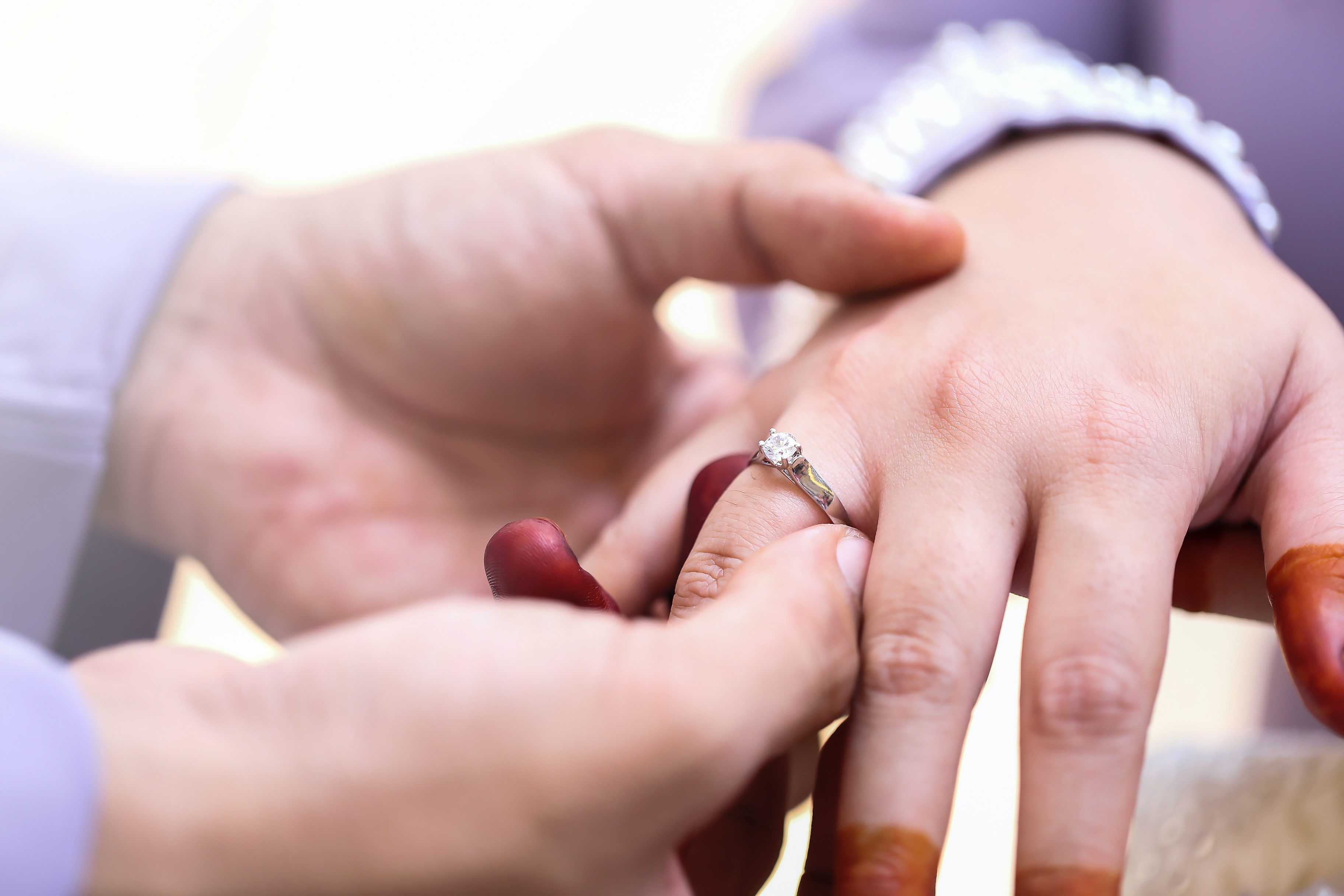 One individual placing a wedding ring on another individual's finger. | Source: Unsplash