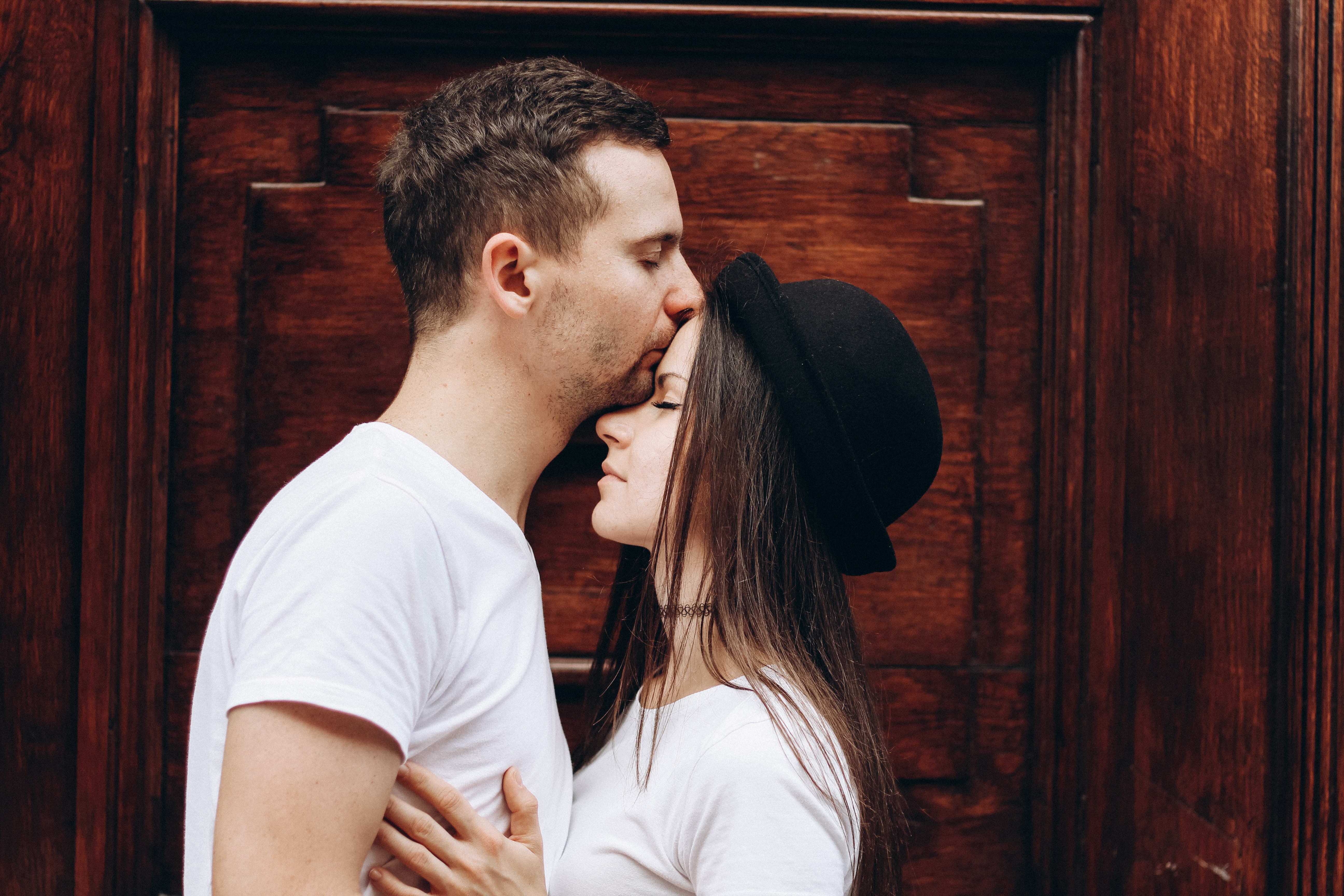 A man kissing a woman on the forehead. | Source: Unsplash