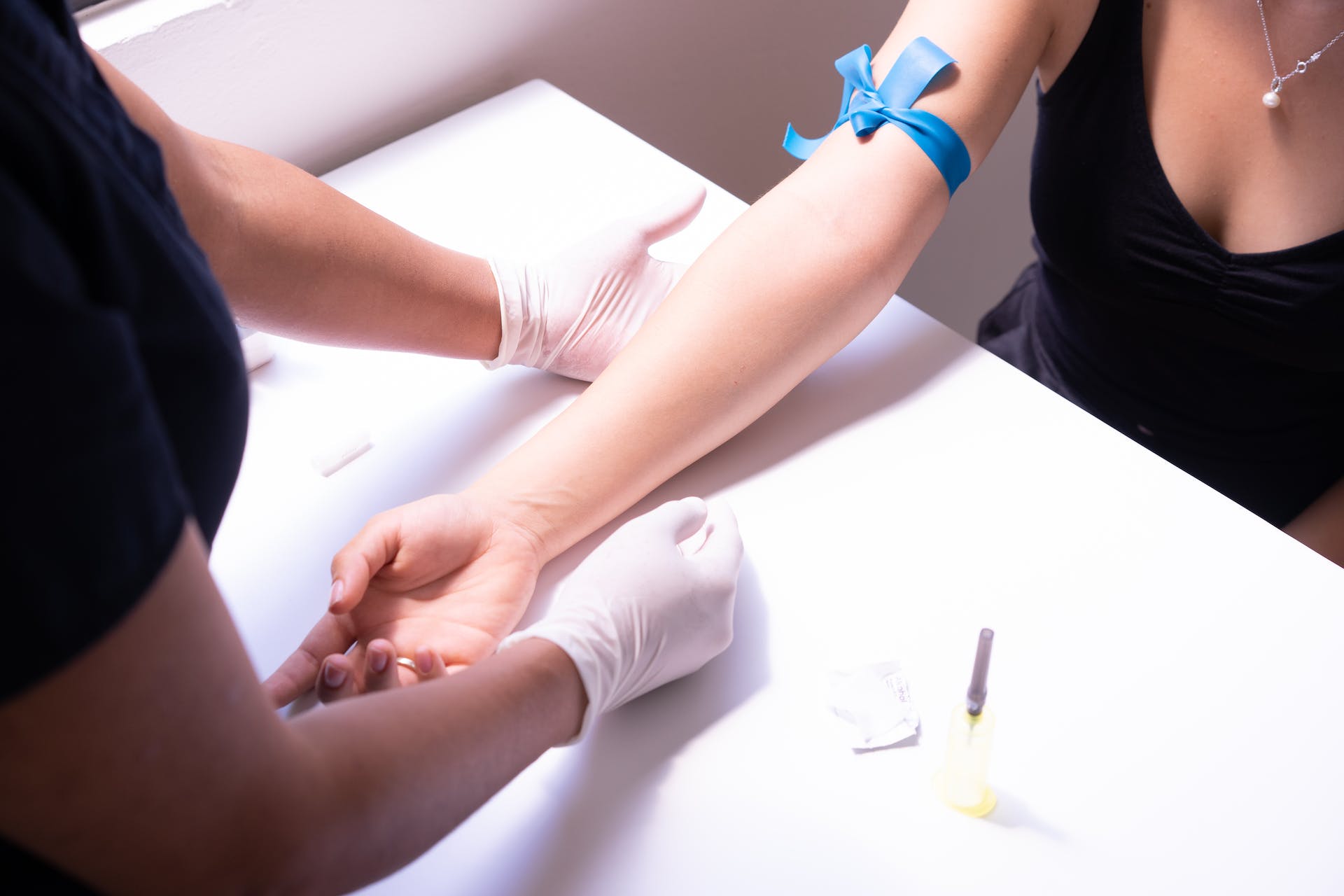 A medical professional preparing a woman for a blood test | Source: Pexels