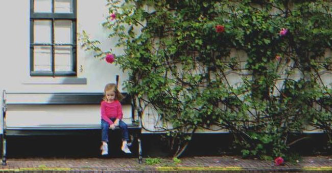 A little girl sitting on a bench | Source: Shutterstock