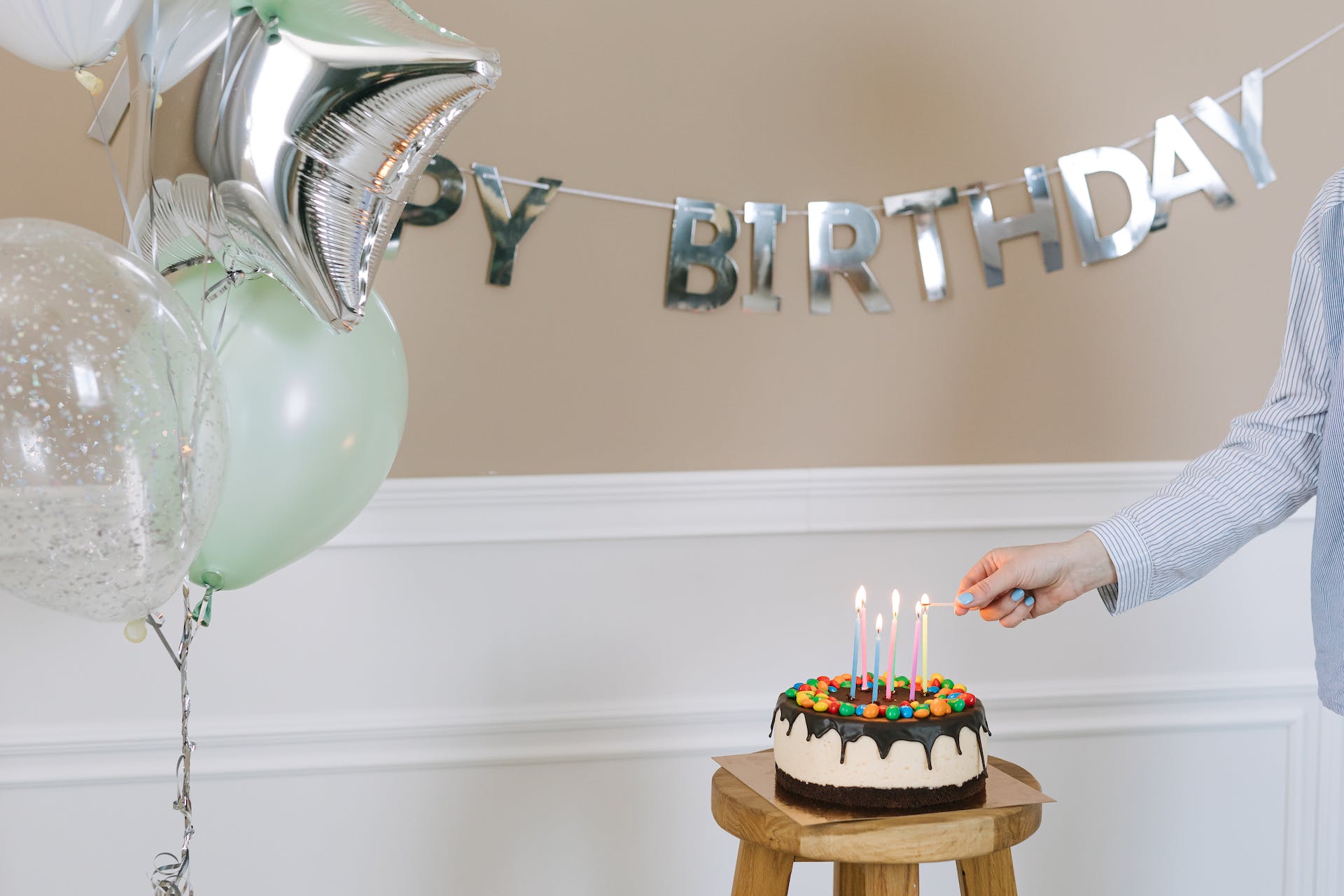 A person lighting a candle on a birthday cake | Source: Pexels