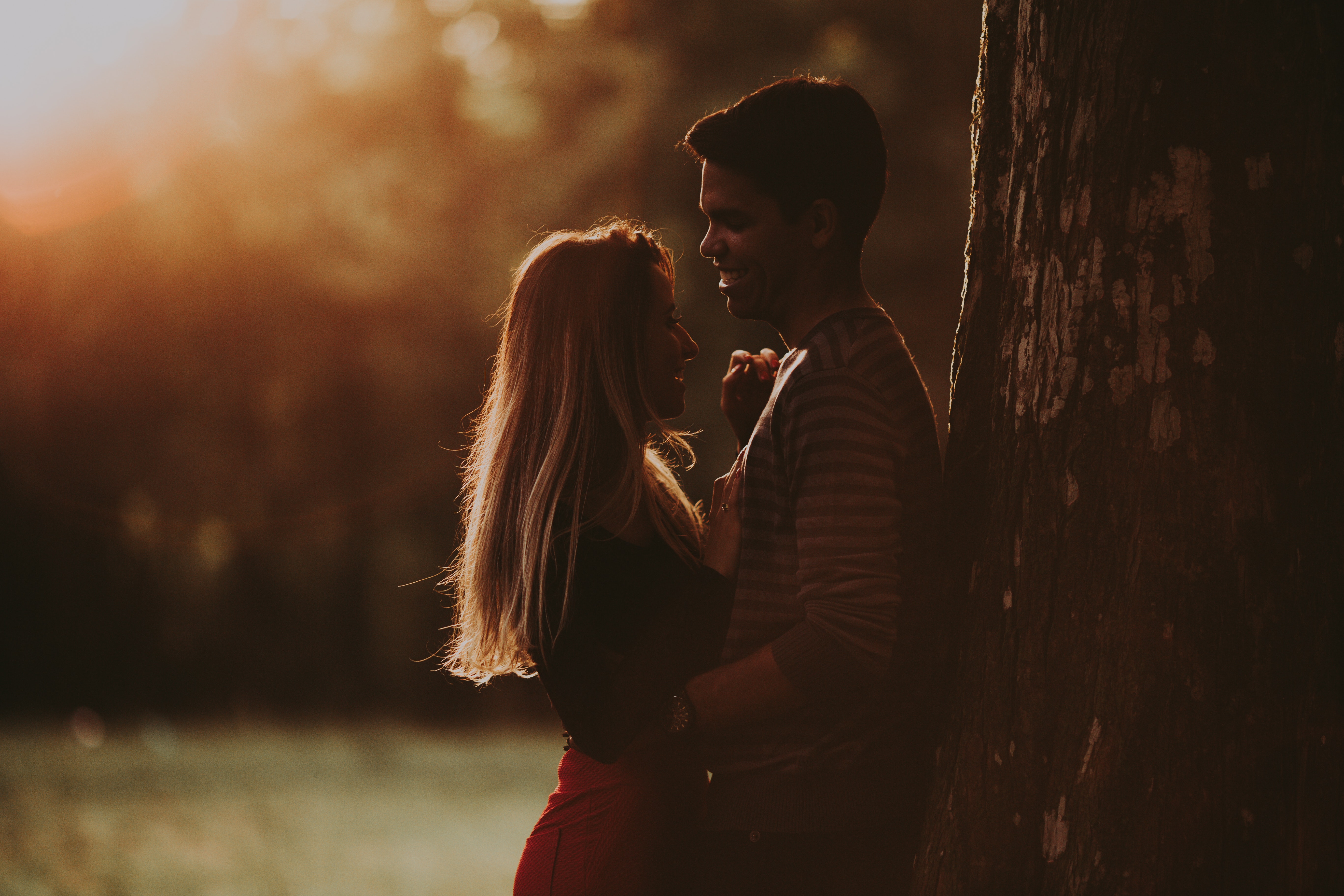 Silhouette of a Couple Standing Close and Smiling at Sunset. | Source: Pexels
