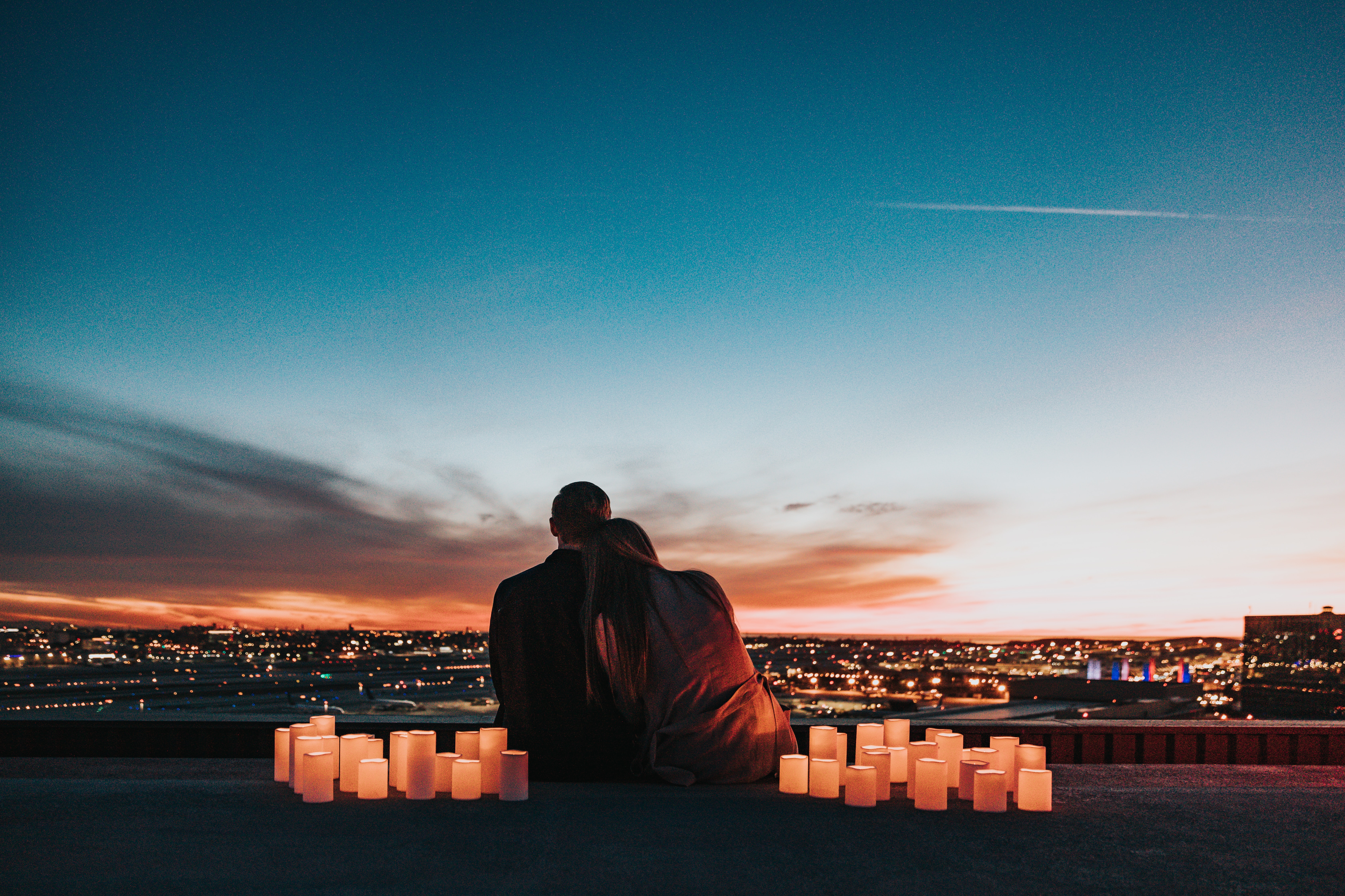 A couple surrounding by candles looking at a city. | Source: Unsplash