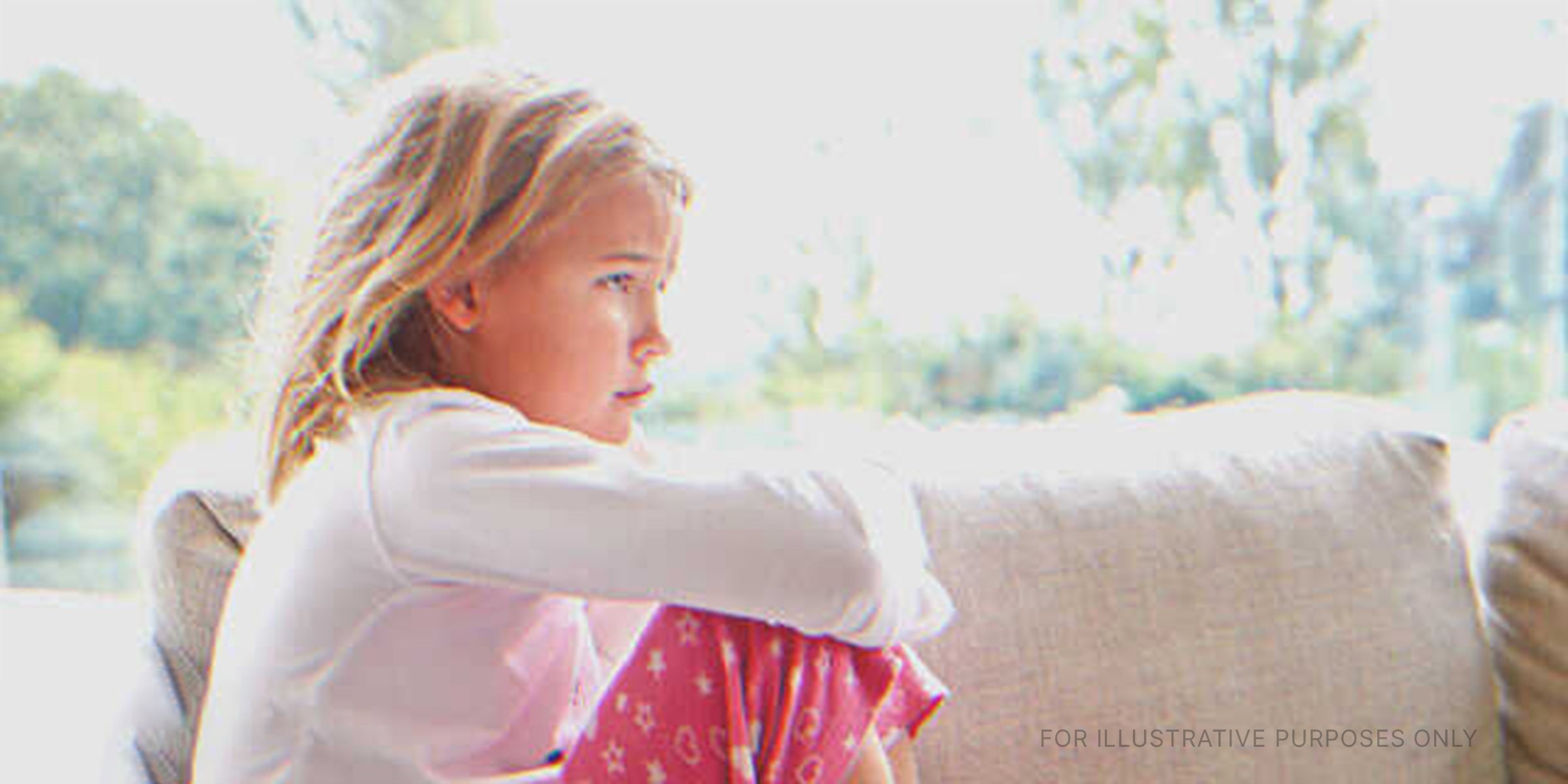 Sad Little Girl Sitting On The Couch. | Source: Shutterstock