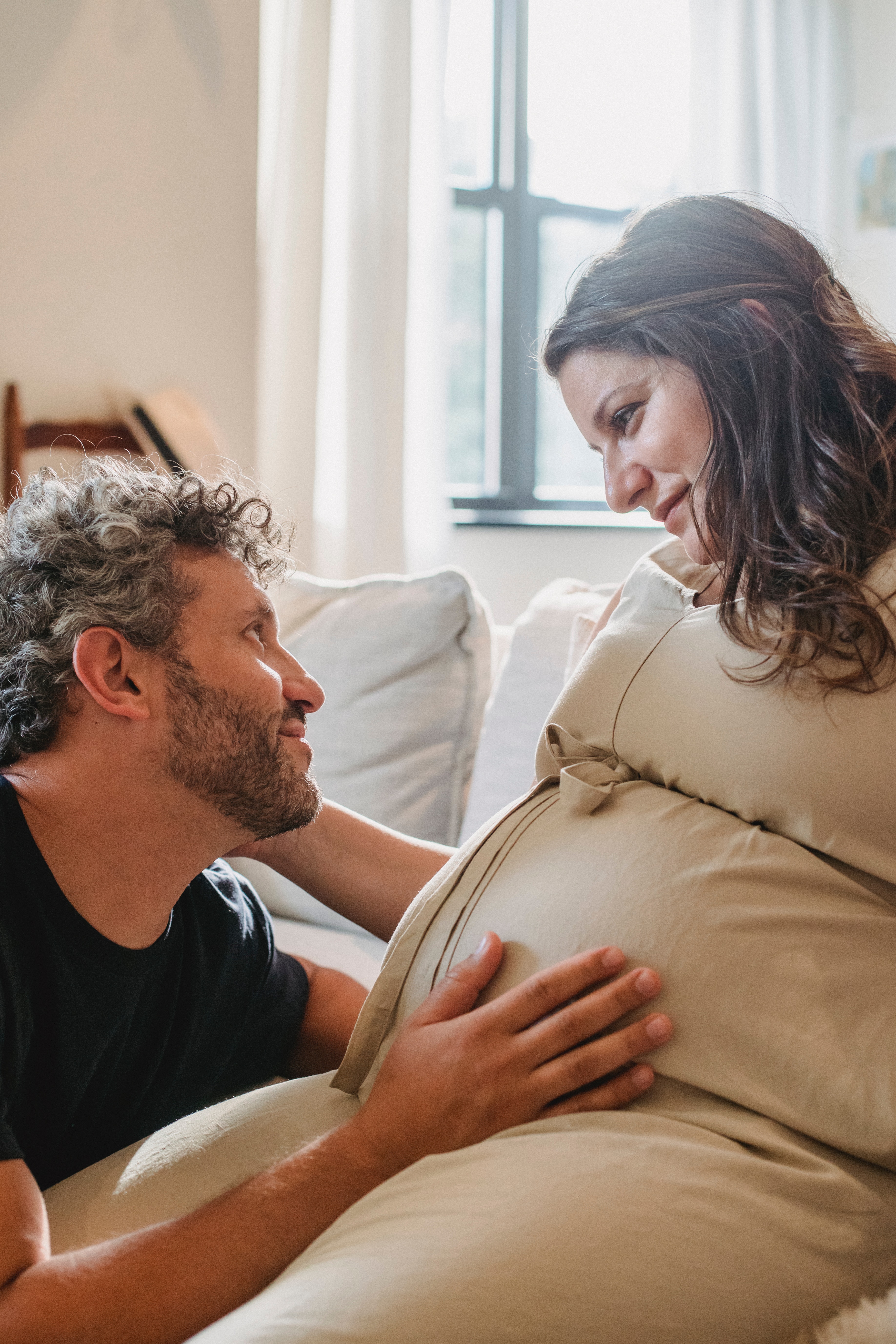 A pregnant woman and her partner gazing lovingly at one another. | Source: Pexels