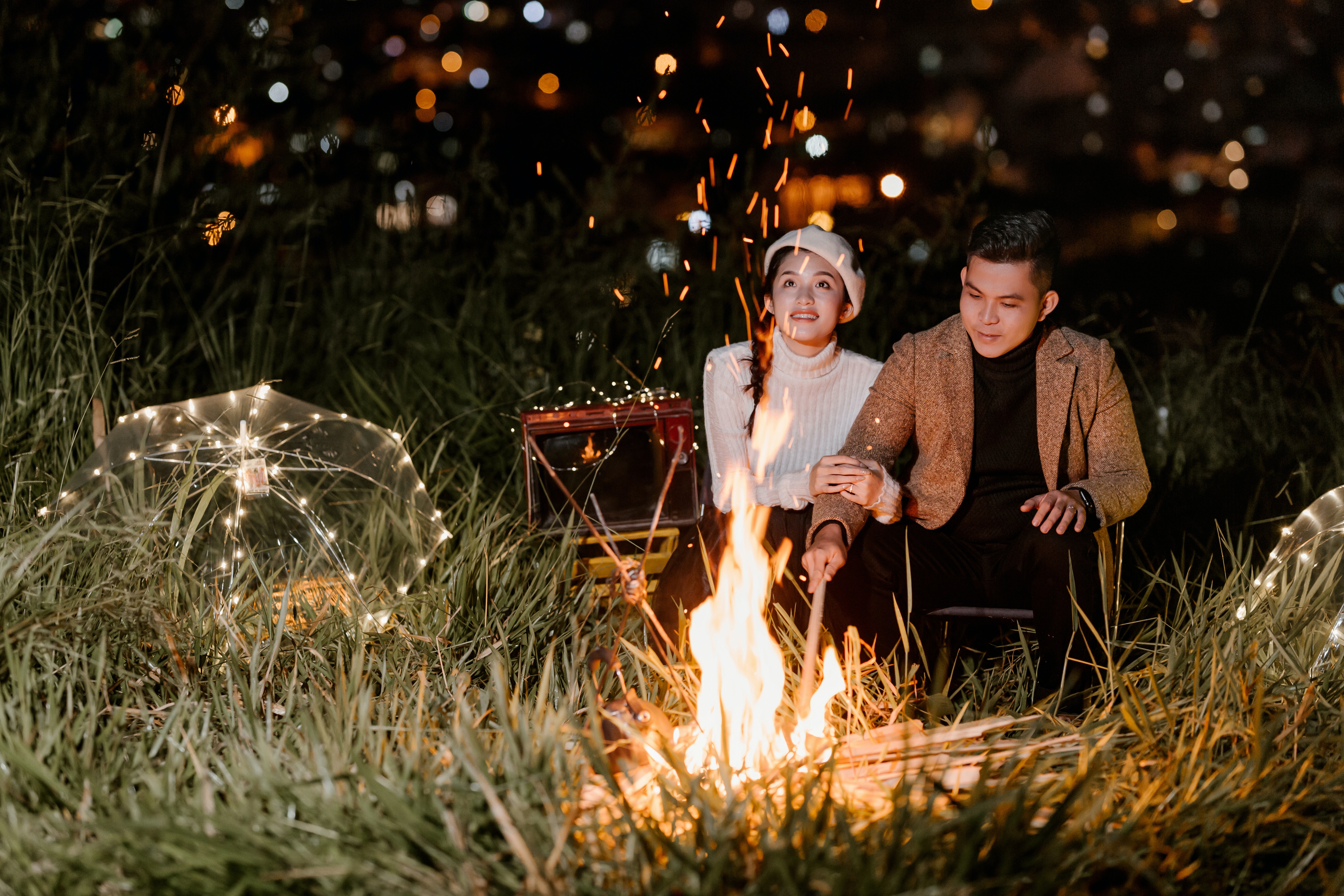A couple sitting by a bonfire. | Source: Pexels