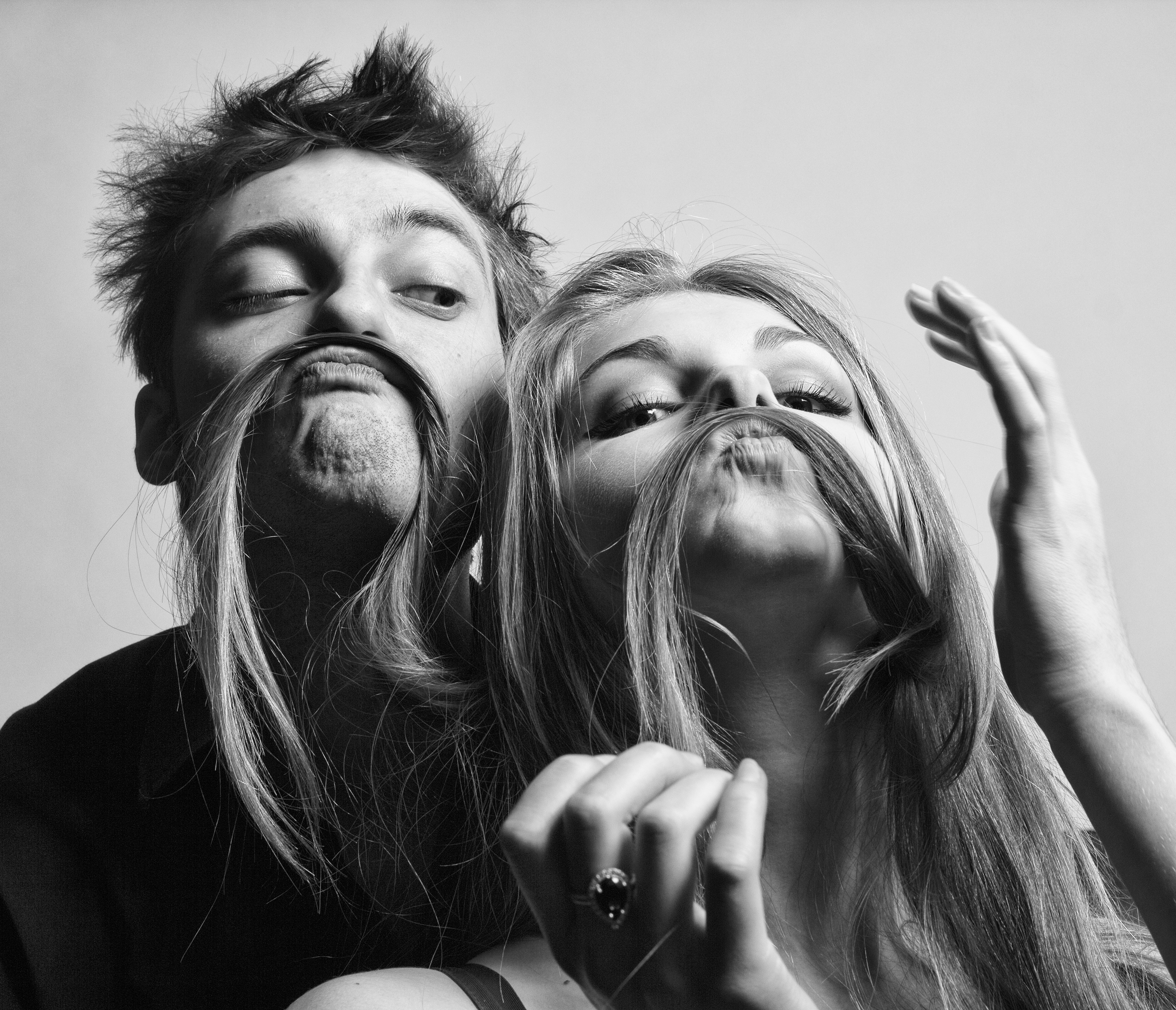 A young couple posing happily for a goofy photo | Source: Shutterstock