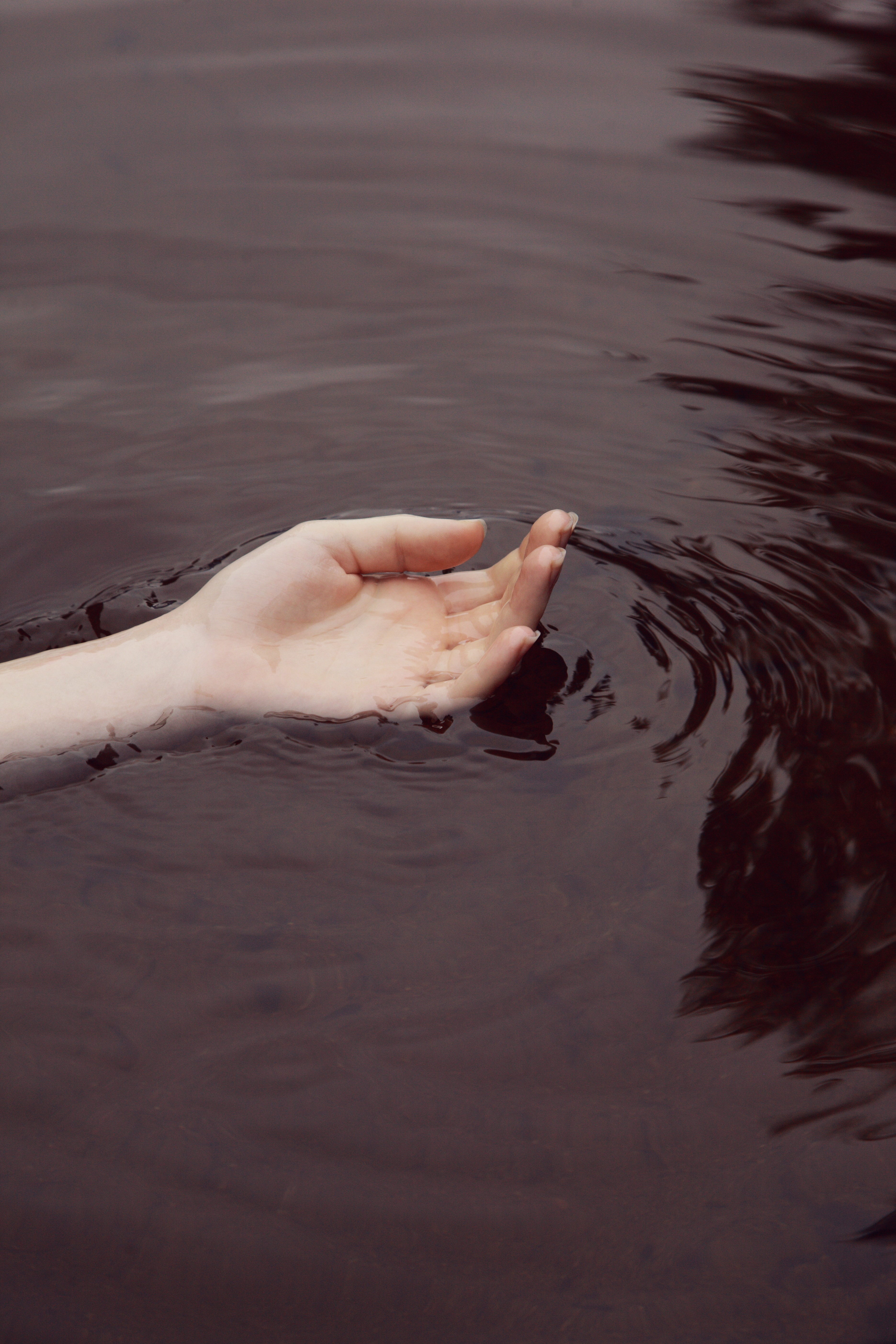 A hand floating in water. | Source: Unsplash