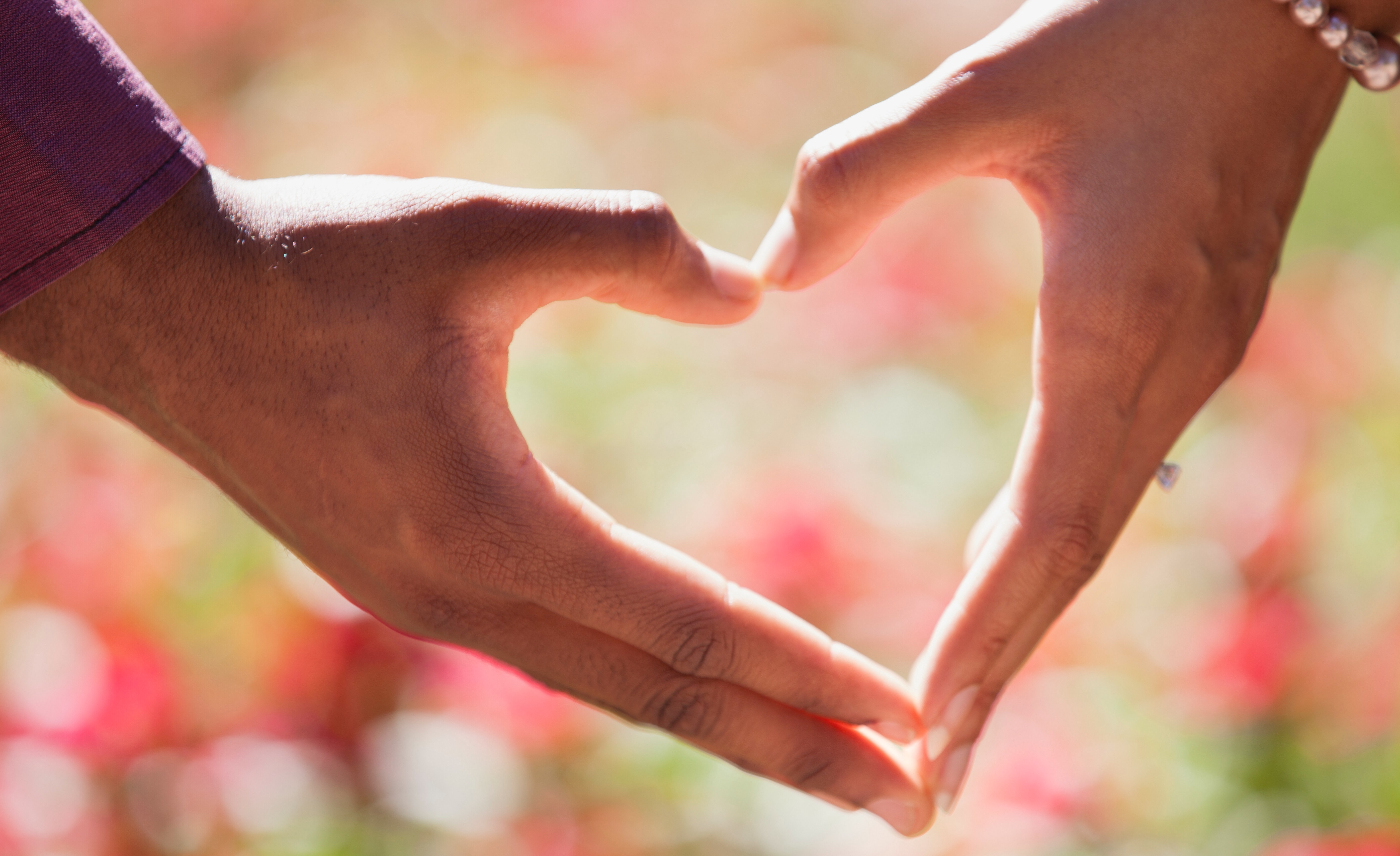 Heart hand on shallow focus lens. | Source: Pexels