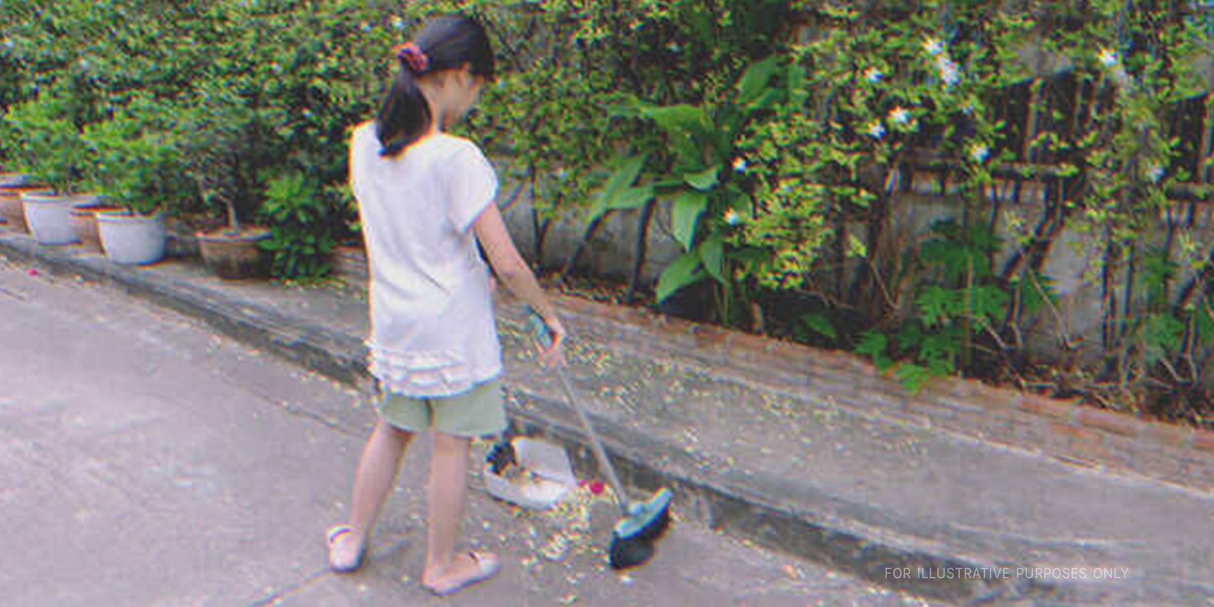 Girl sweeping the street. | Shutterstock