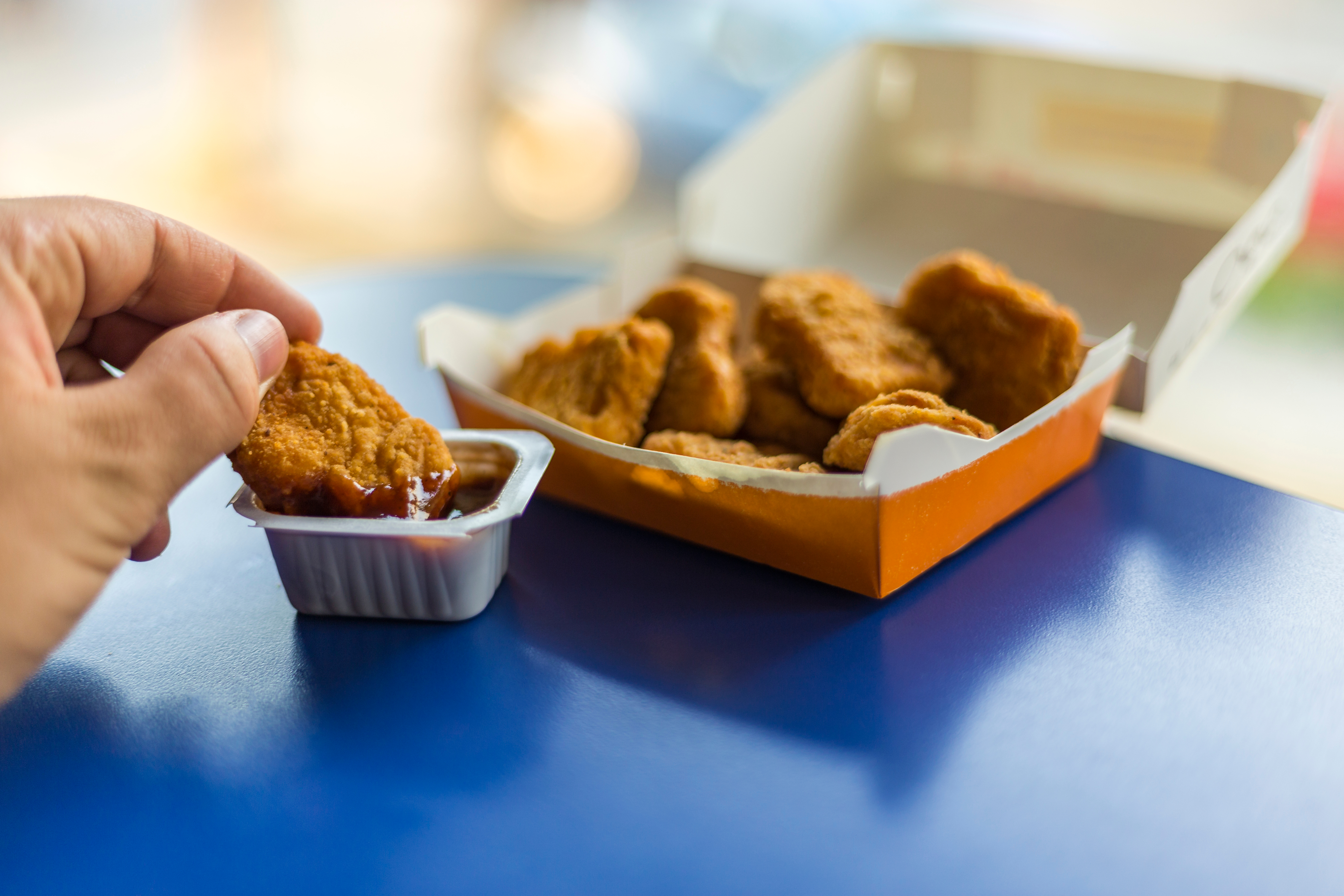 A person dipping a nugget in a sauce | Source: Shutterstock