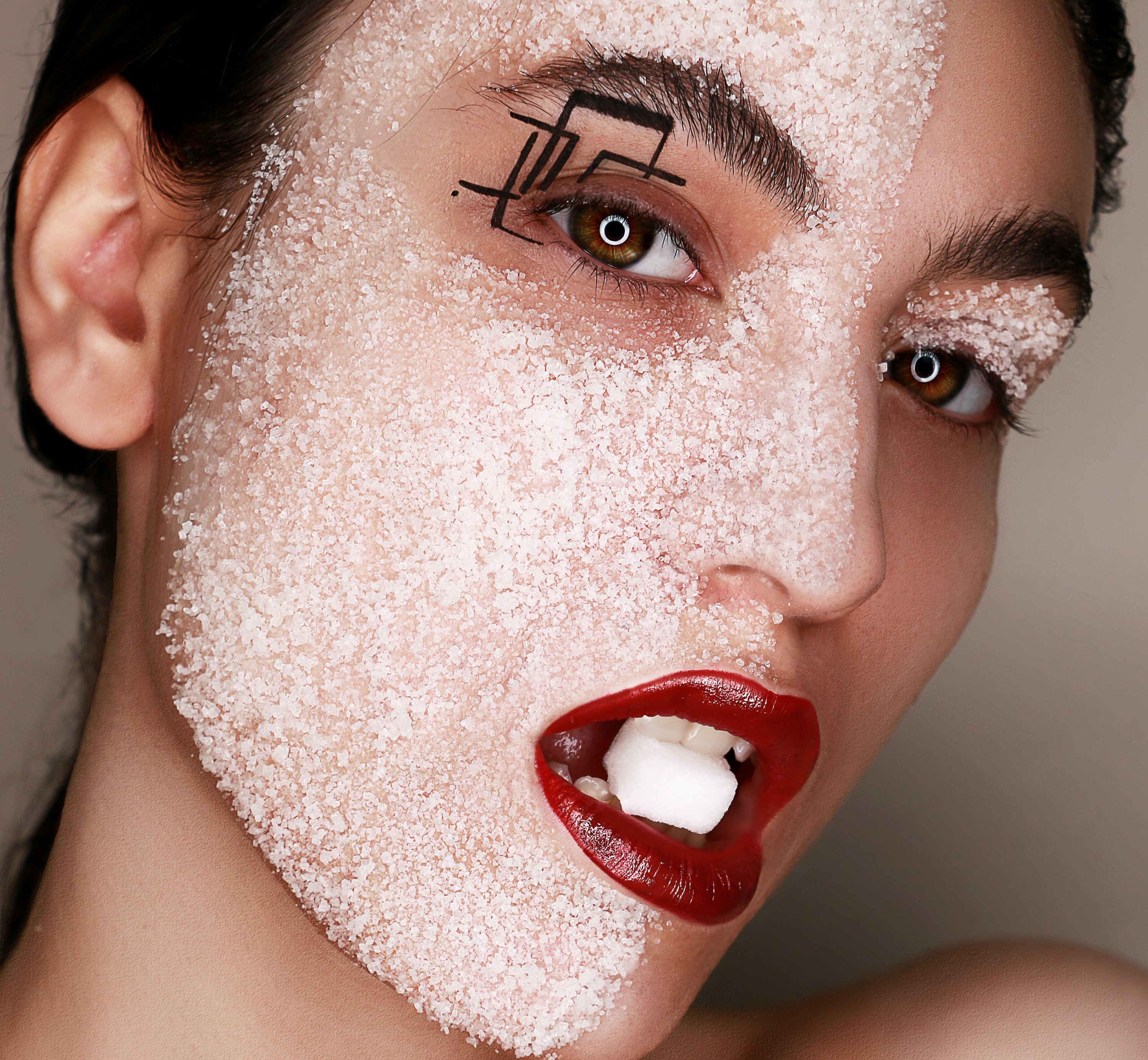 A woman with a sugar cube in her mouth.┃Source: Pexels