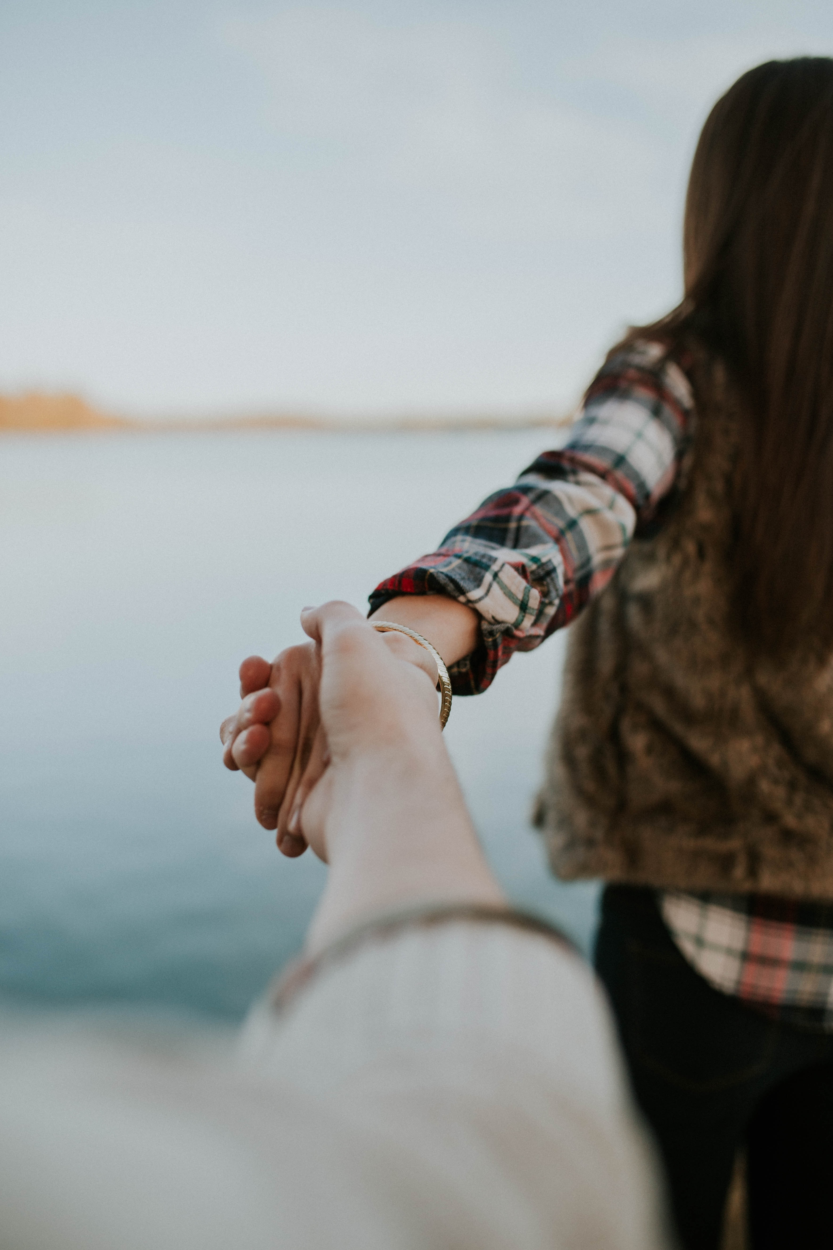 A woman leading her boyfriend by the hand | Source: Unsplash