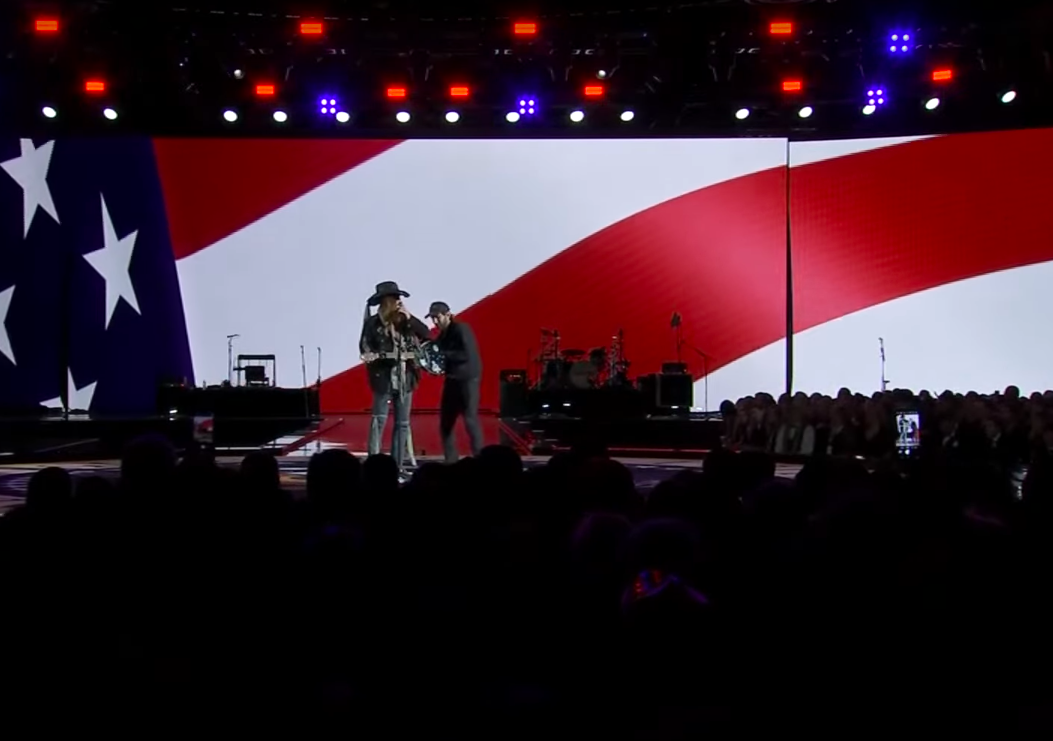 A technician trying to help fix the sound issues that Billy Ray Cyrus was facing. | Source: YouTube/PBS NewsHour