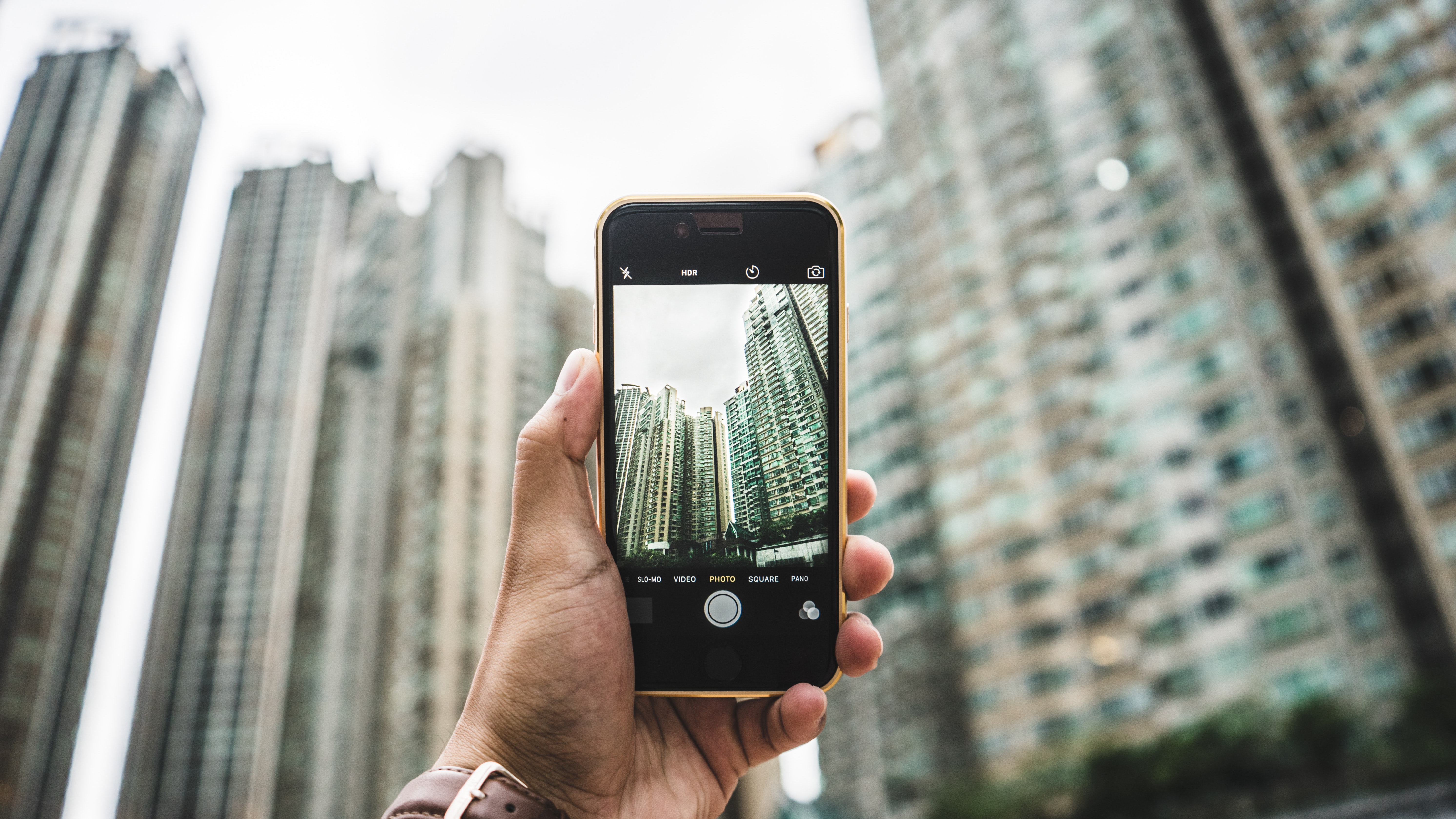 A man taking a photo of city towers. | Source: Unsplash