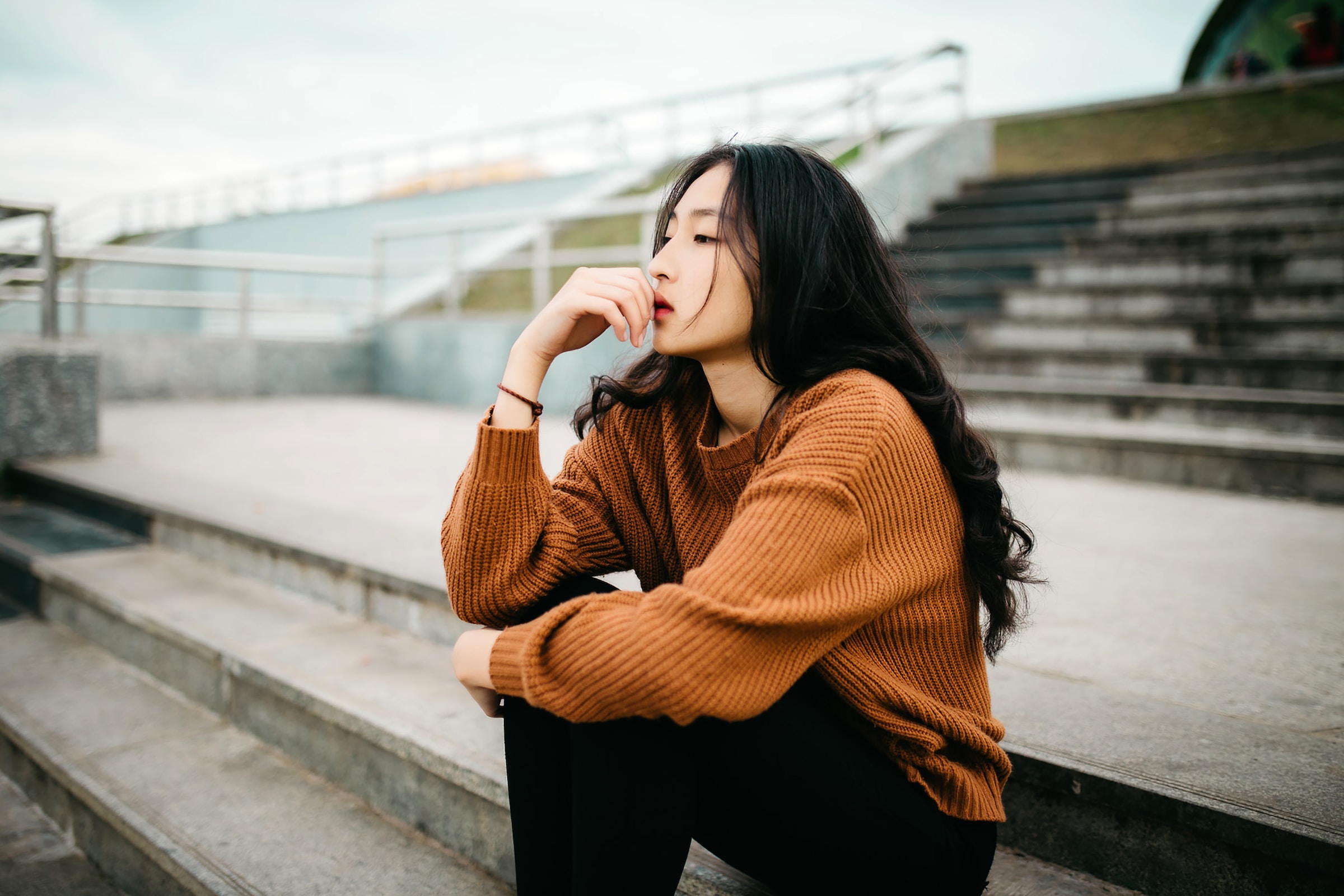 Woman thinking on some steps. | Source: Unsplash