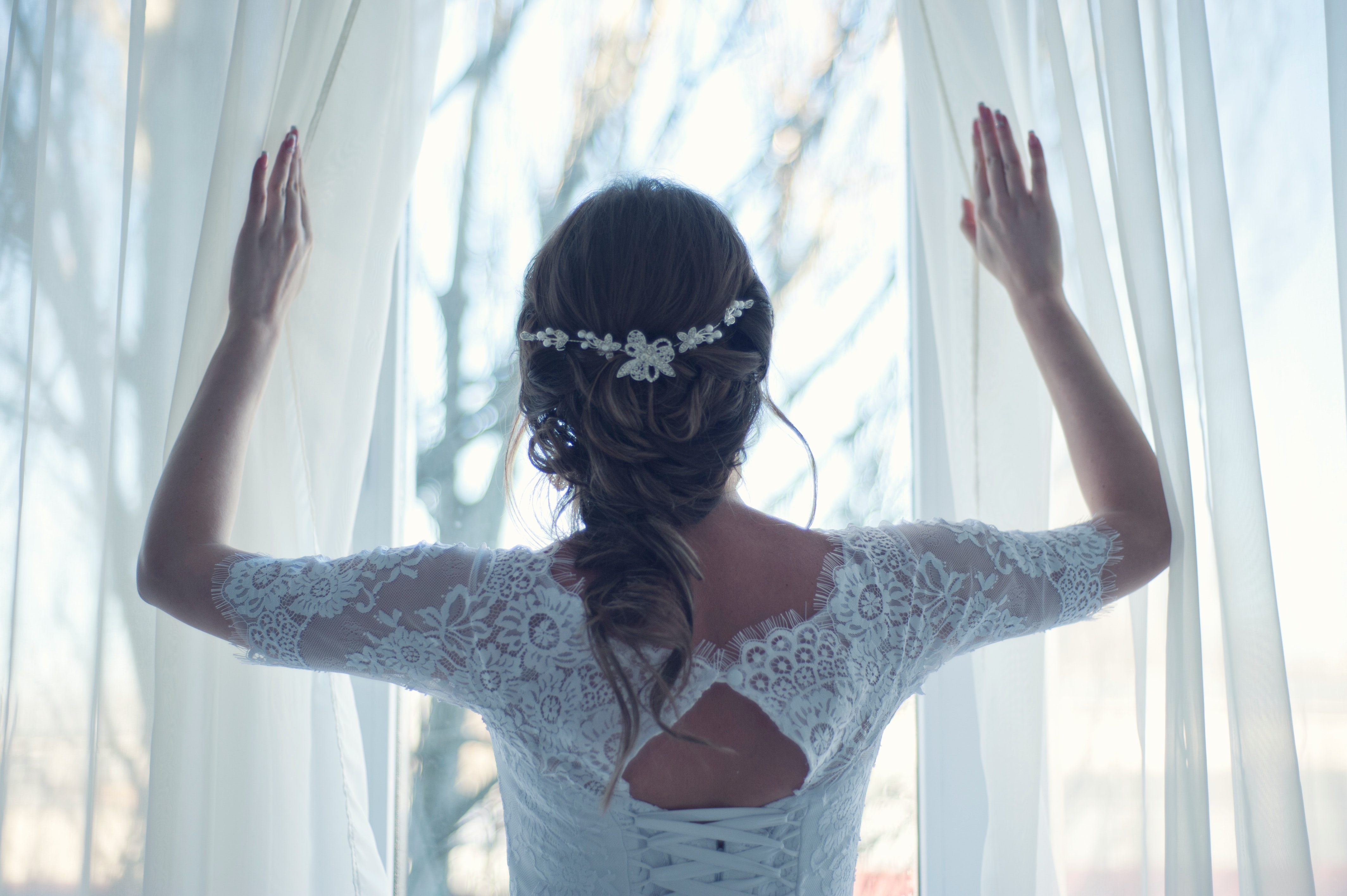 A bride opening curtains. | Source: Pexels
