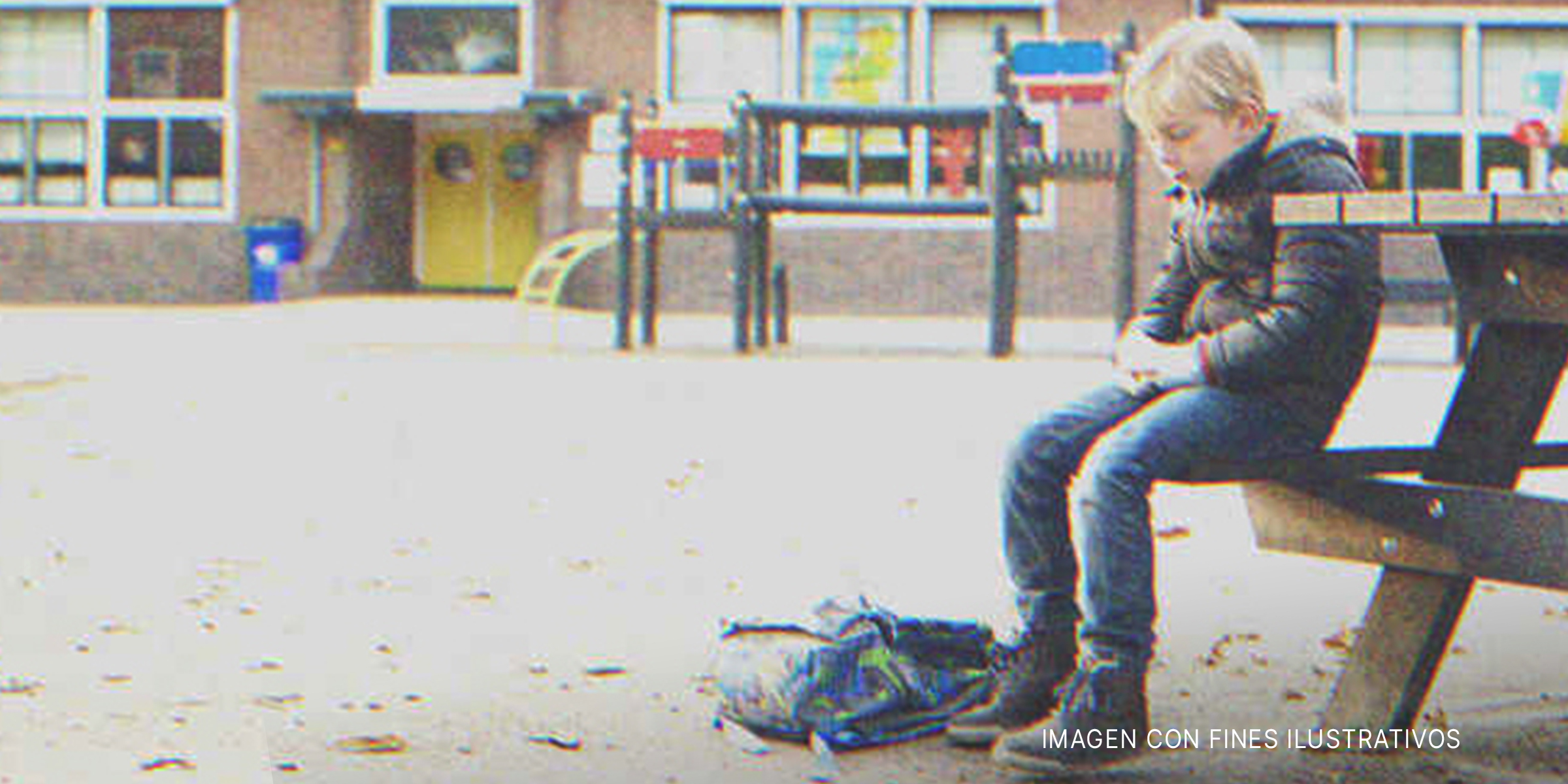 Niño sentado solo en un banco fuera de la escuela. | Foto: Shutterstock