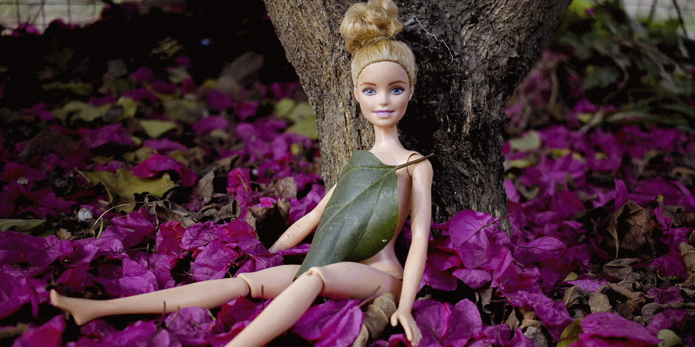 Barbie resting on a tree trunk | Source: Unsplash