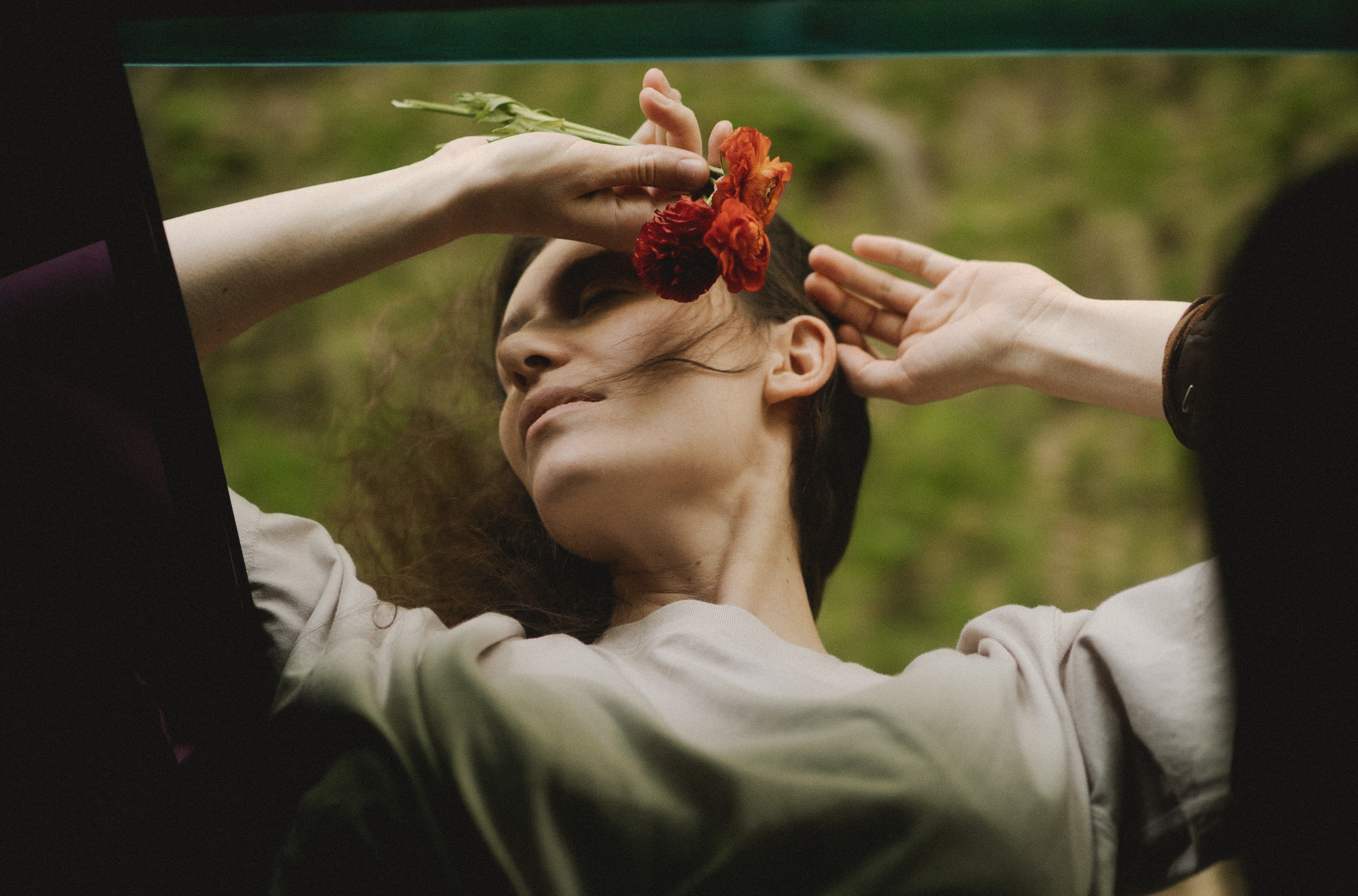 A woman leaning out a car window while holding flowers. | Source: Pexels