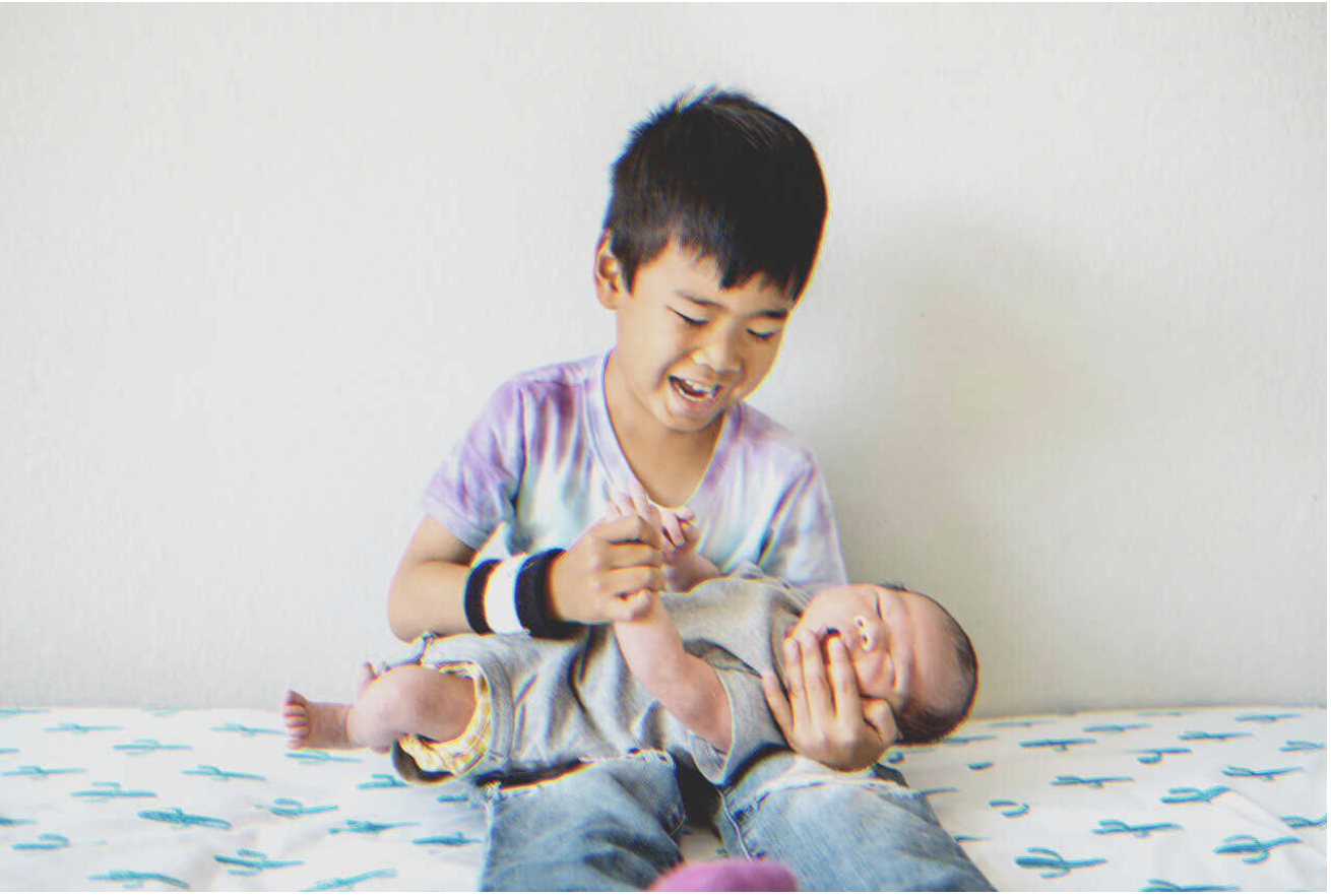 Un niño sostiene a un bebé | Fuente: Shutterstock