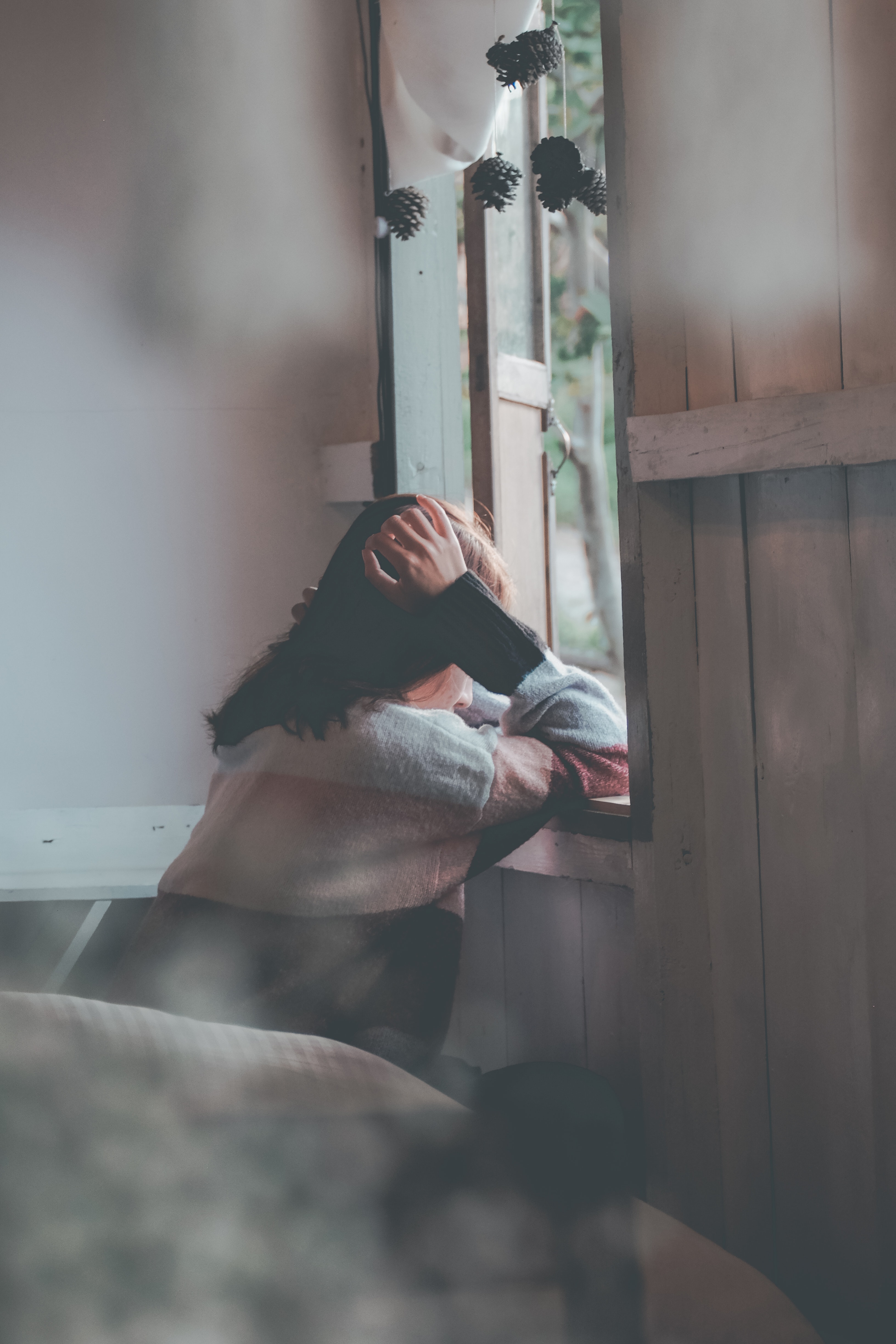 A woman leaning on a window ledge. | Source: Pexels