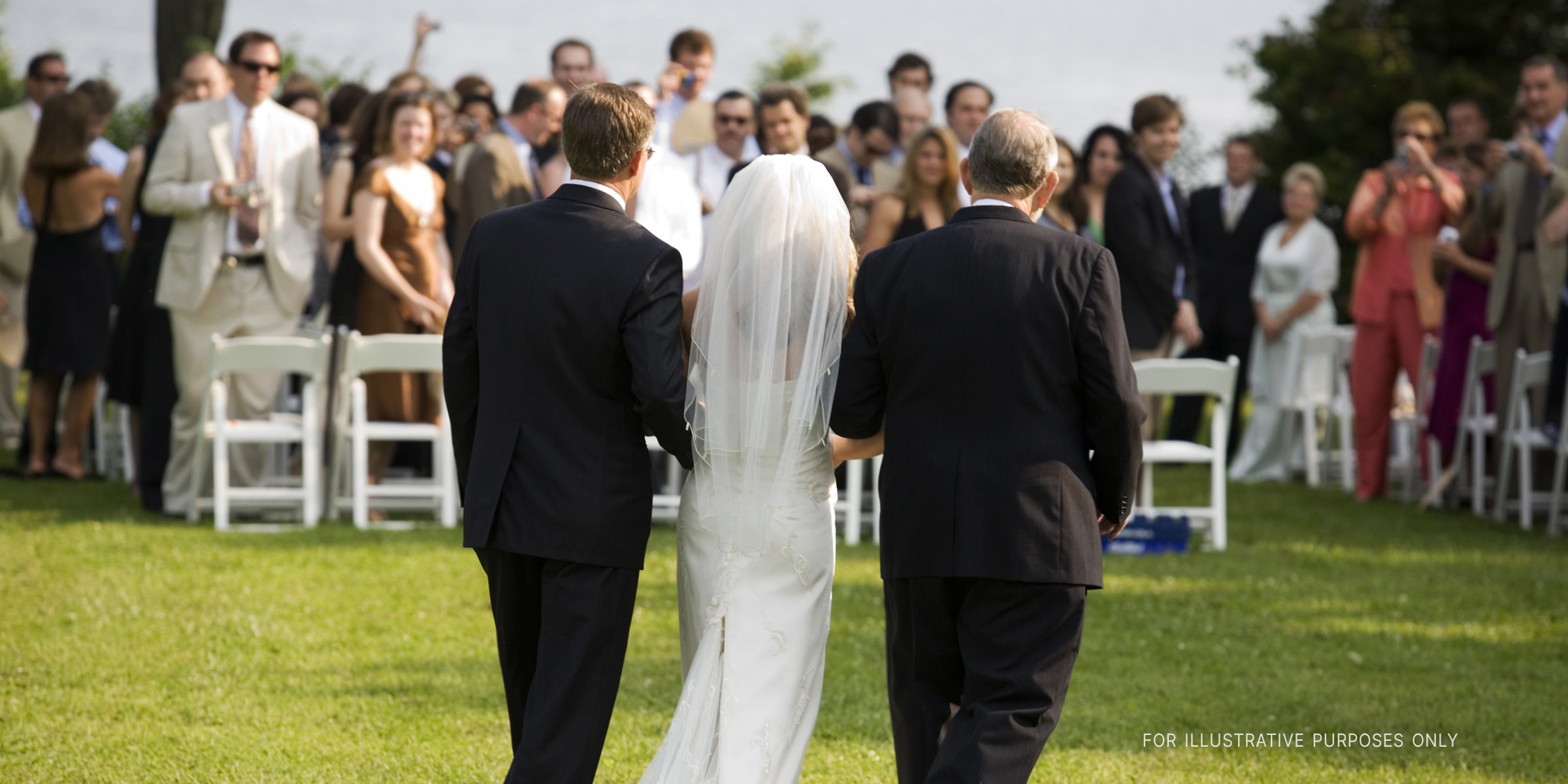 Bride walking down the aisle with two men | Source: Getty Images