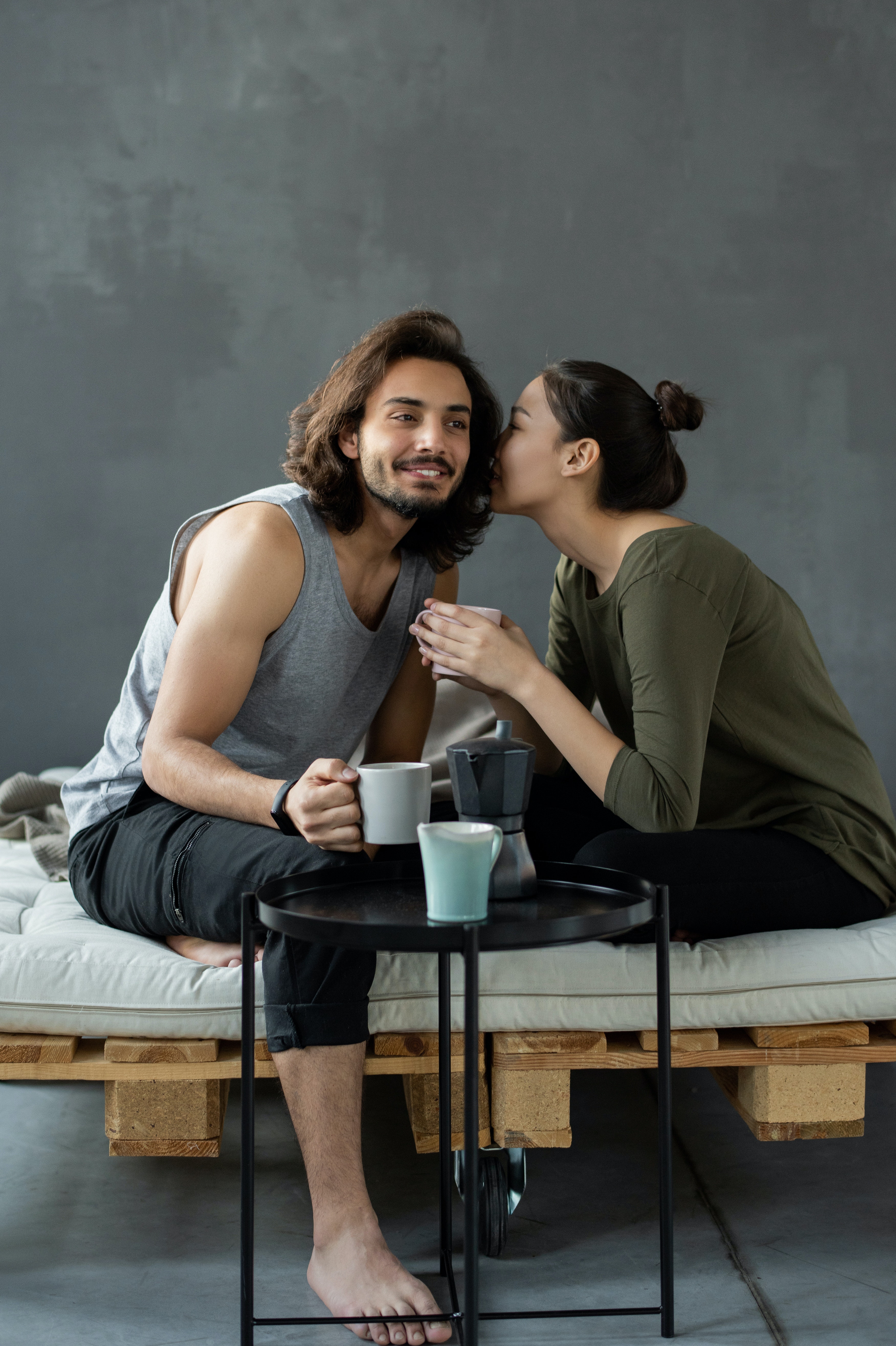 A woman whispering into a man's ear. | Source: Pexels