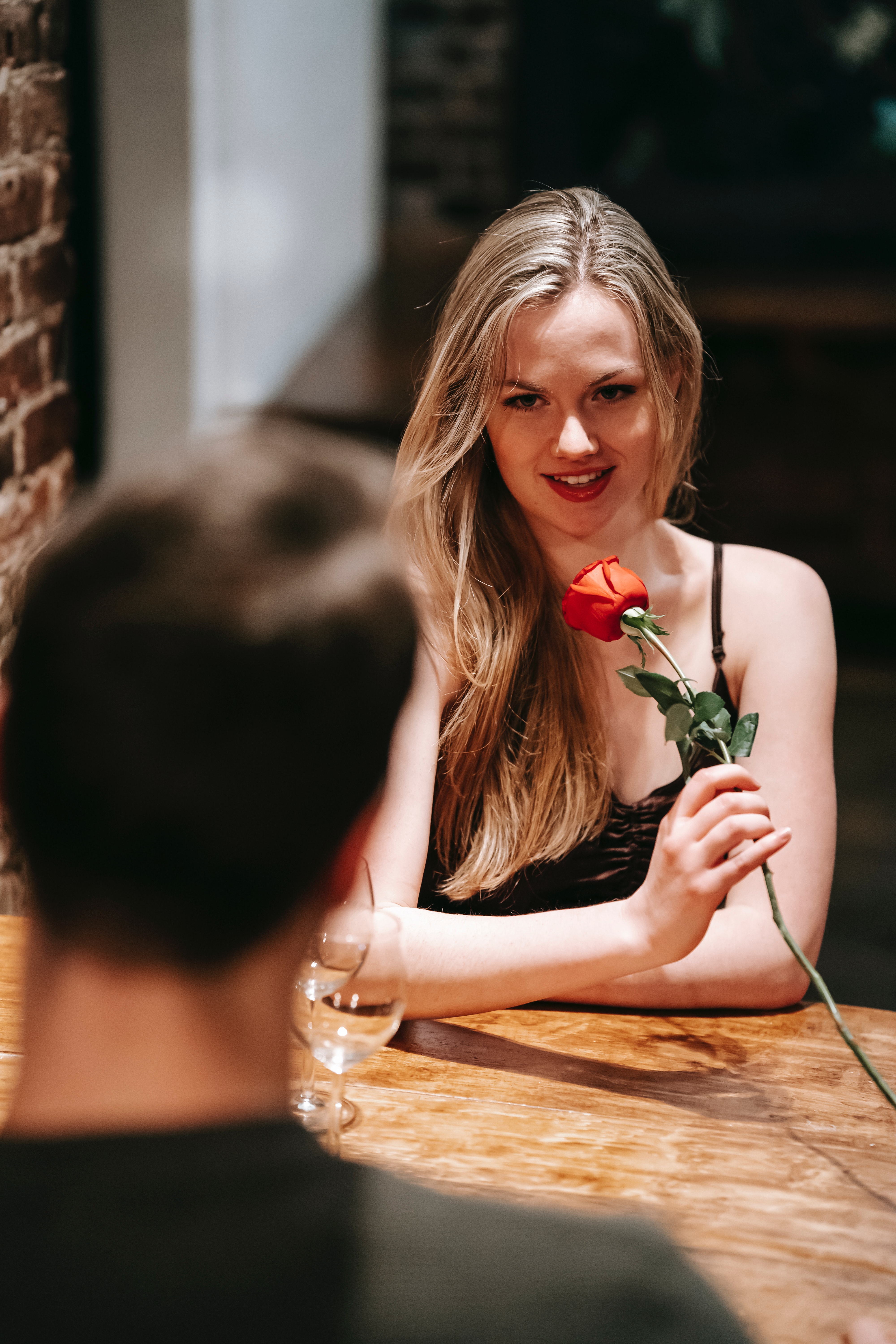 A woman holding a red rose on a date. | Source: Unsplash