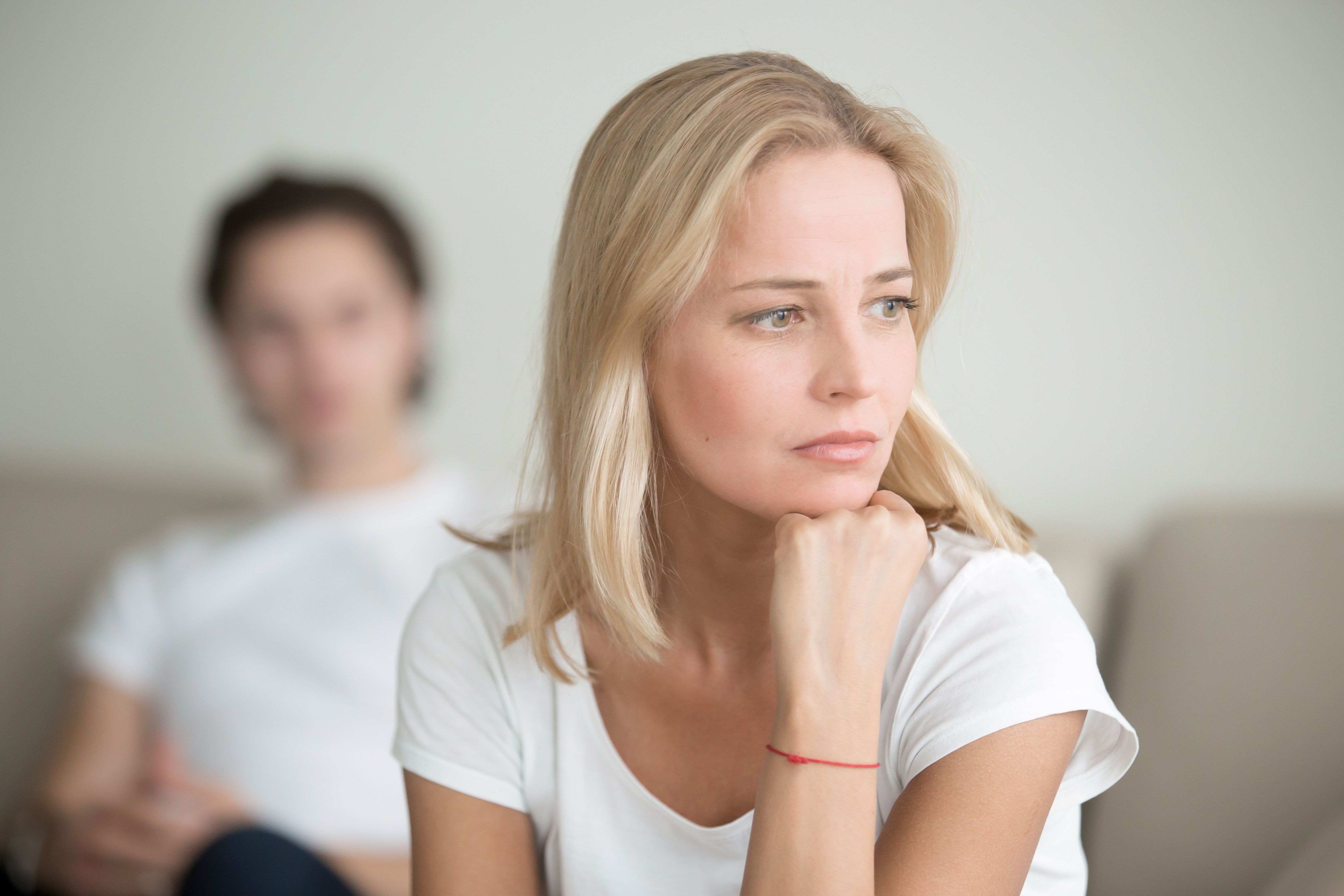 An upset woman and a man behind her. | Source: Shutterstock