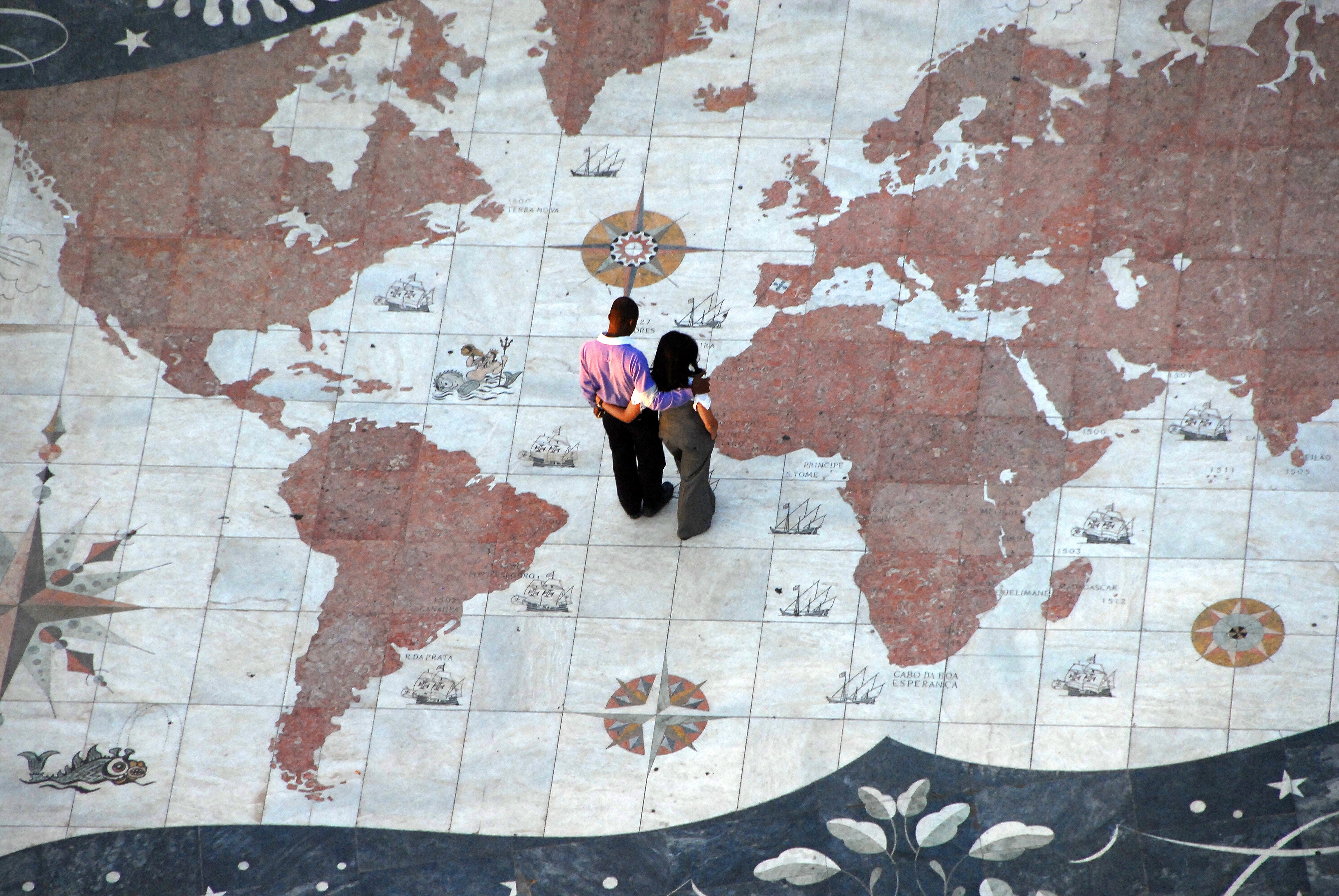 A couple standing on a floor painted as a map. | Source: Pixabay