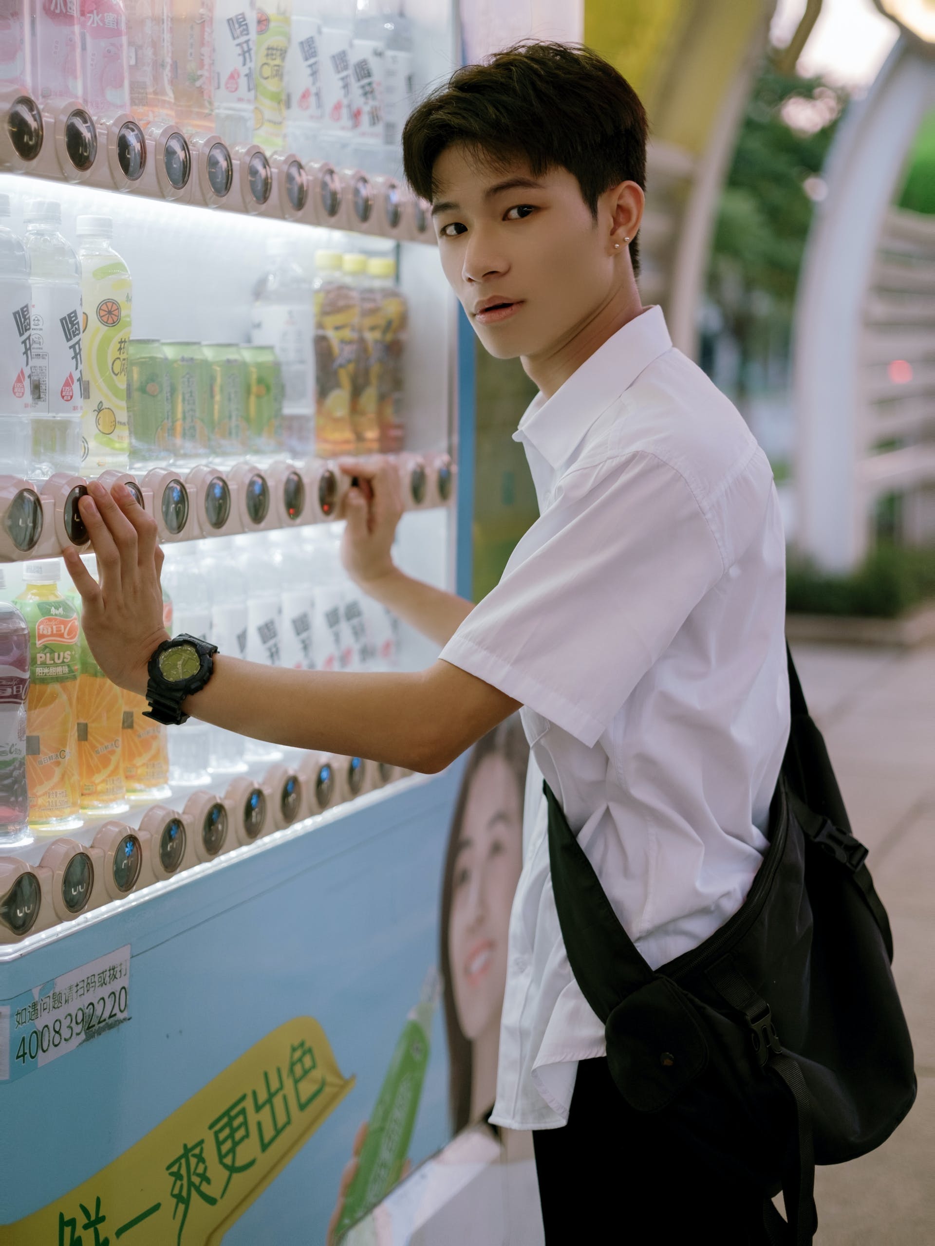 A boy standing next to a vending machine | Source: Pexels