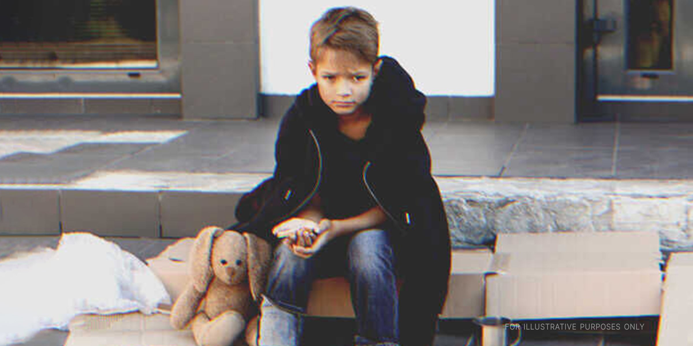 Sad boy sitting on the street | Shutterstock 