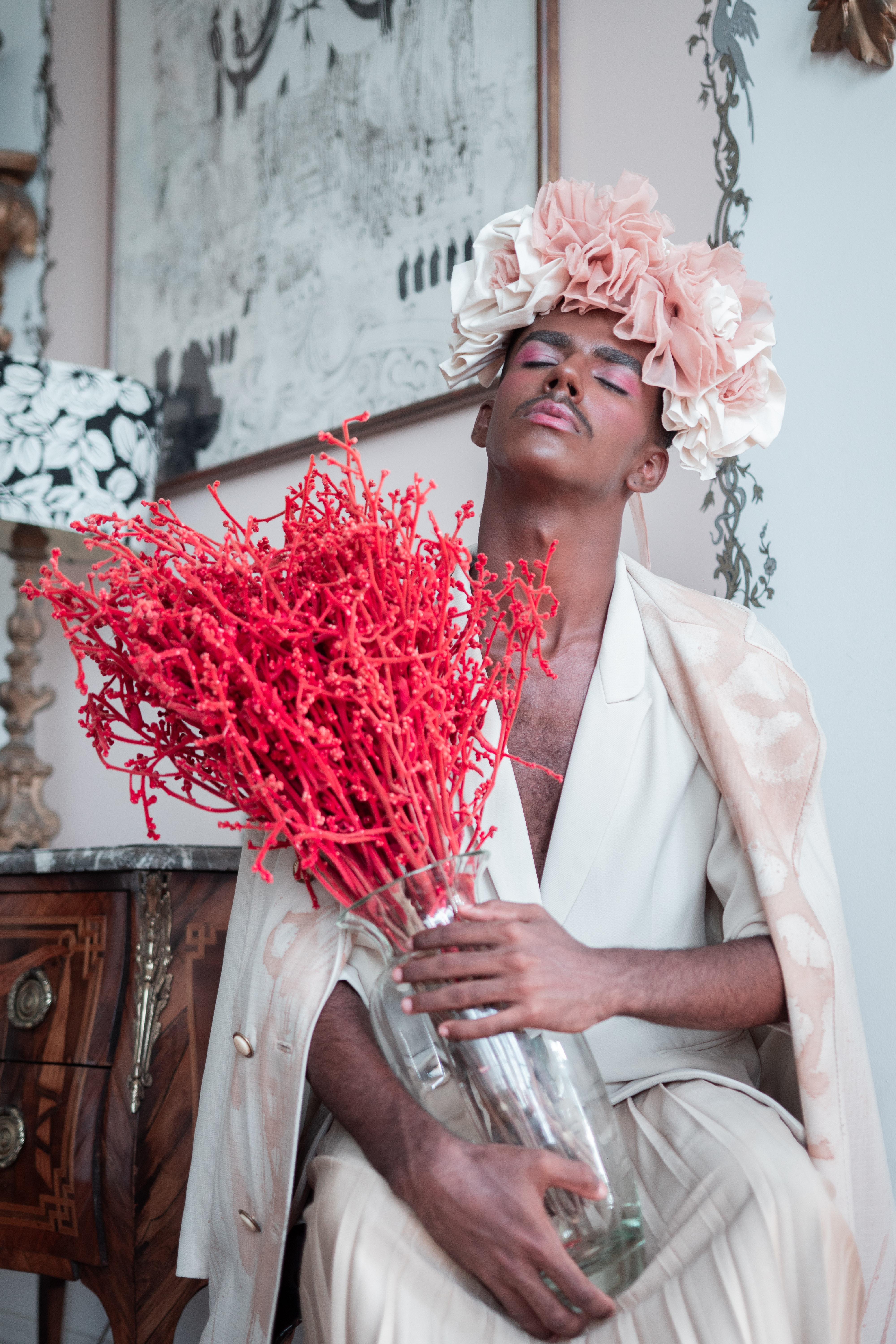 A man in a dress holding flowers. | Source: Pexels