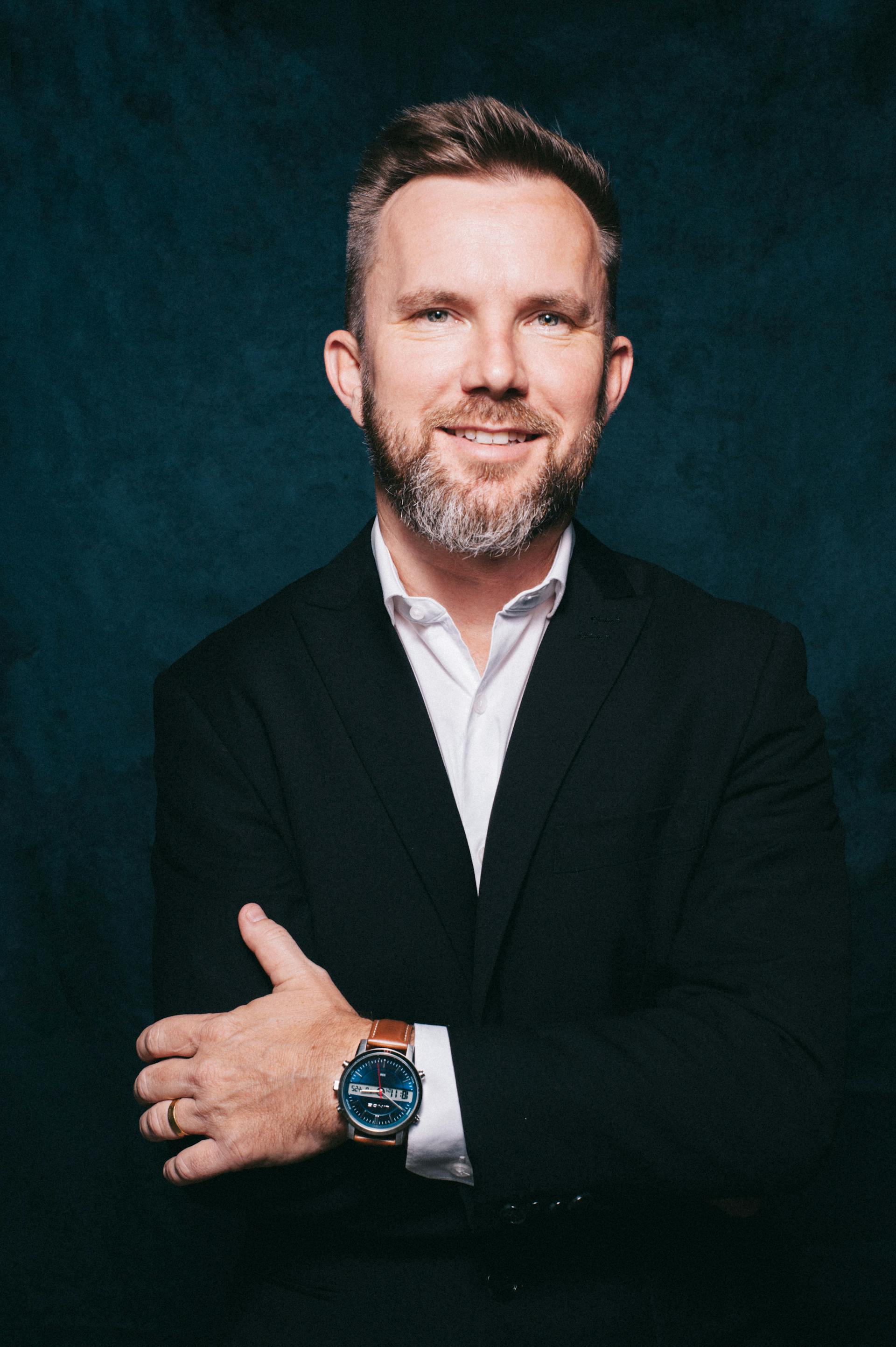 Uśmiechnięty mężczyzna w średnim wieku w garniturze | Źródło: Pexels